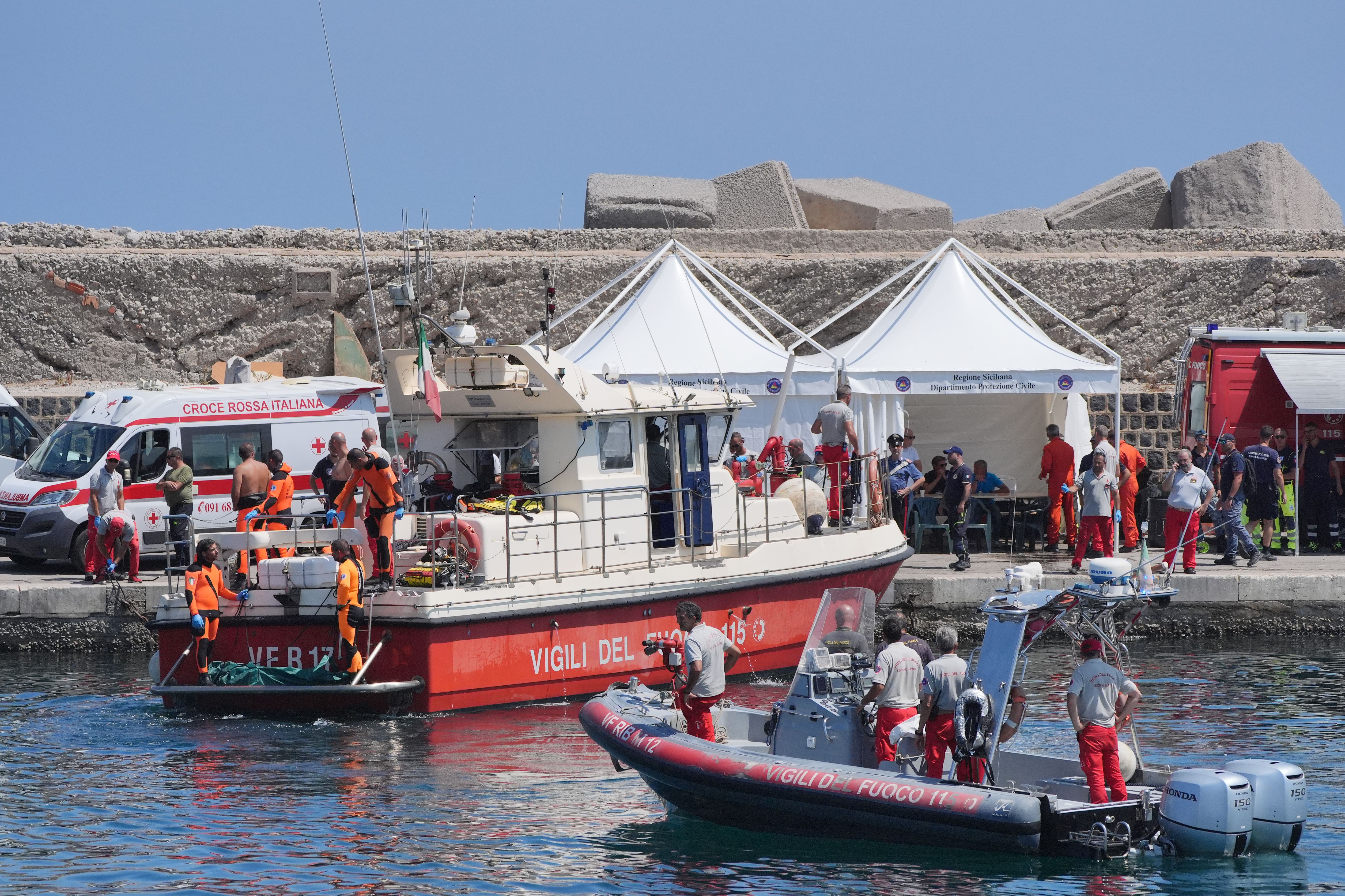 A body bag is brought ashore at the harbour in Porticello on the fifth day of the search and recovery operation