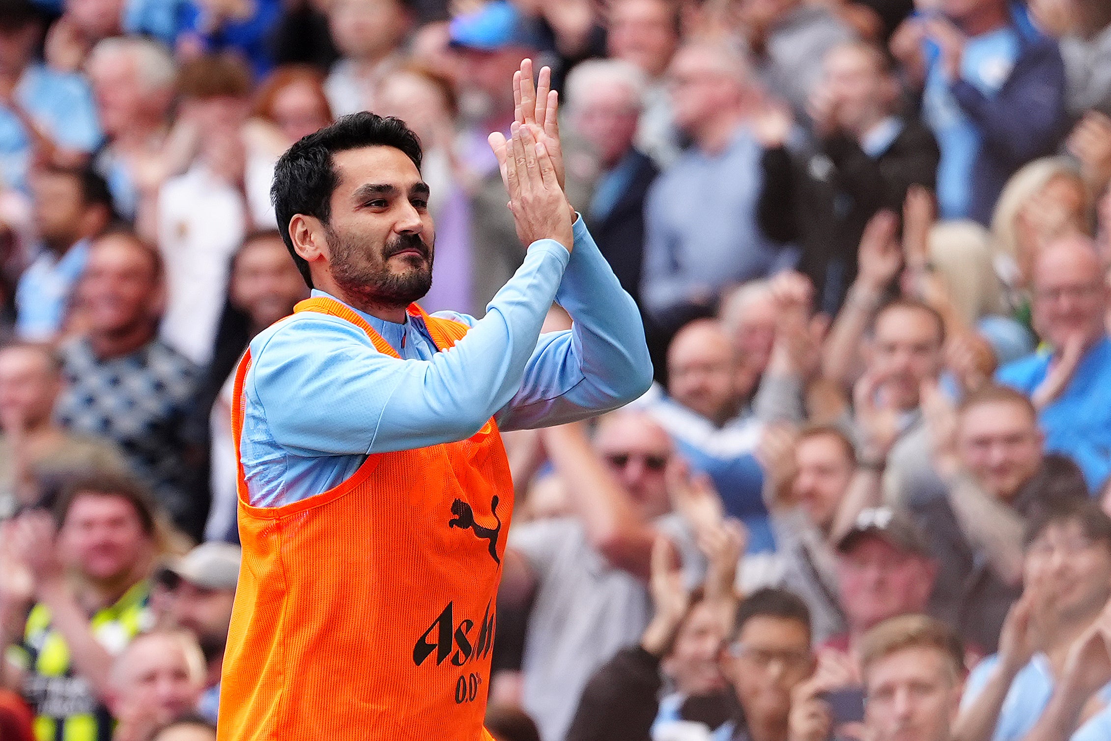 Ilkay Gundogan applauds fans as he warms up ahead of his second debut (Peter Byrne/PA)