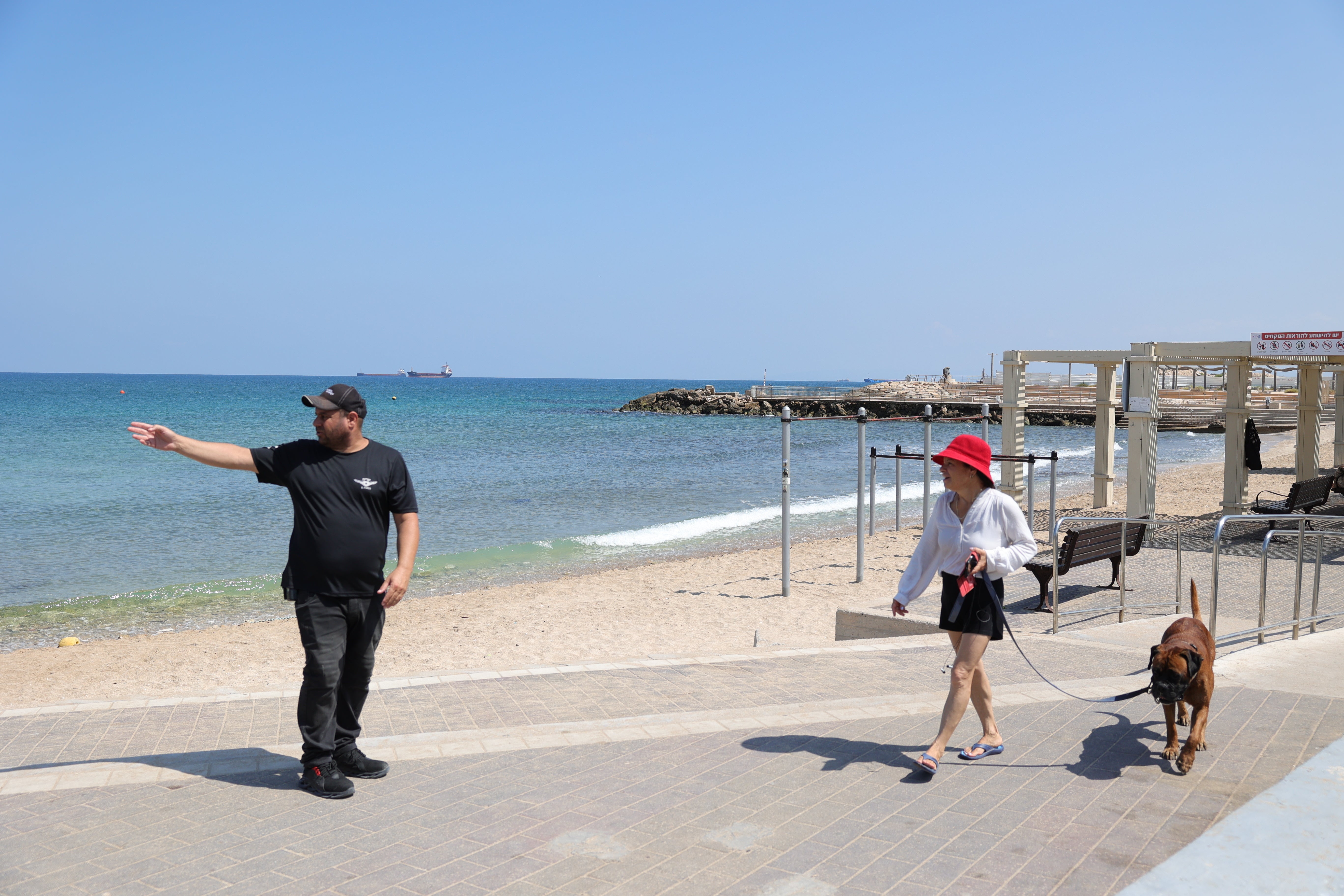 A municipality inspector asks a woman to get out of the sea in the northern city of Haifa, Israel