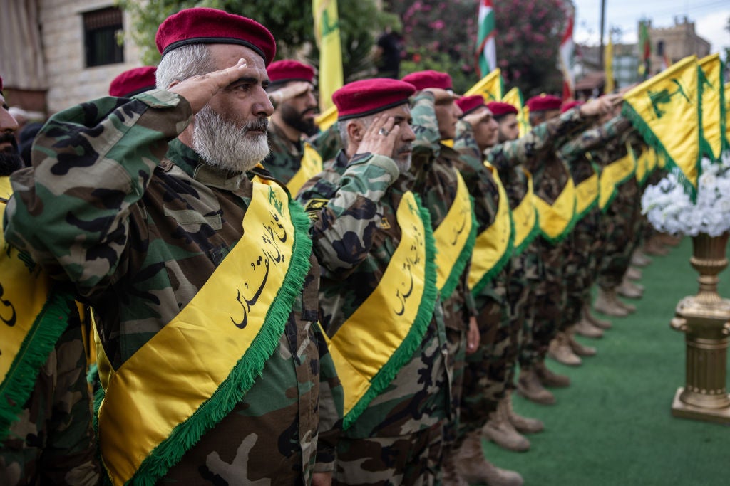 Hezbollah soldiers salute as the coffin of Hezbollah fighter Mohamad Bader el Dine who was killed in an Israeli drone strike on his car in August, arrives in the Christian village of Marjayoun