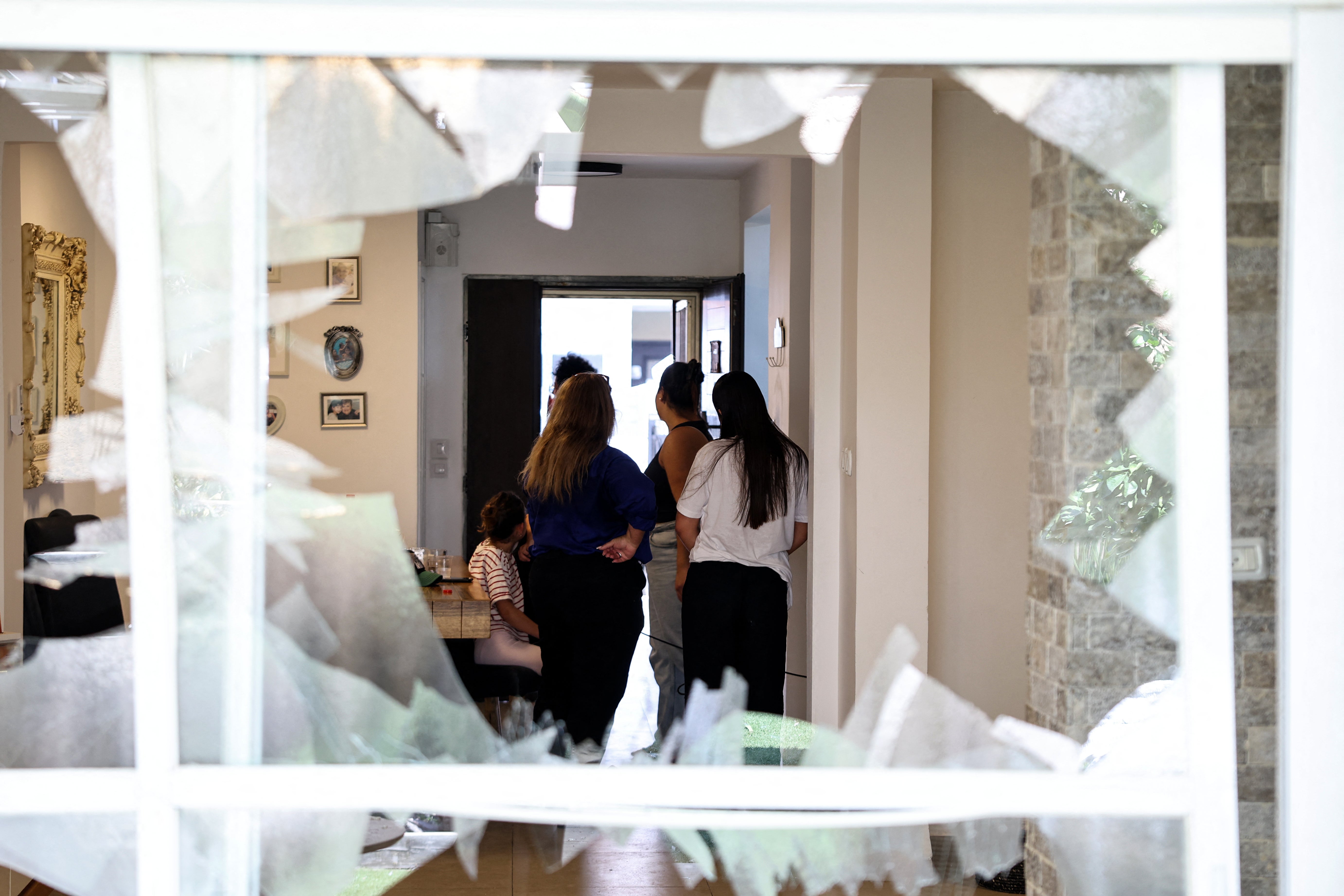 Residents check the damage caused by a strike from Lebanon in the Israeli coastal town of Acre during Sunday’s attack