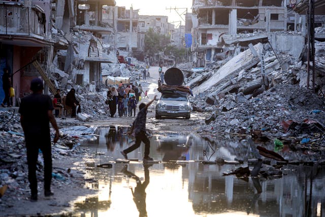 <p>Palestinians walk past sewage in the Gaza Strip </p>