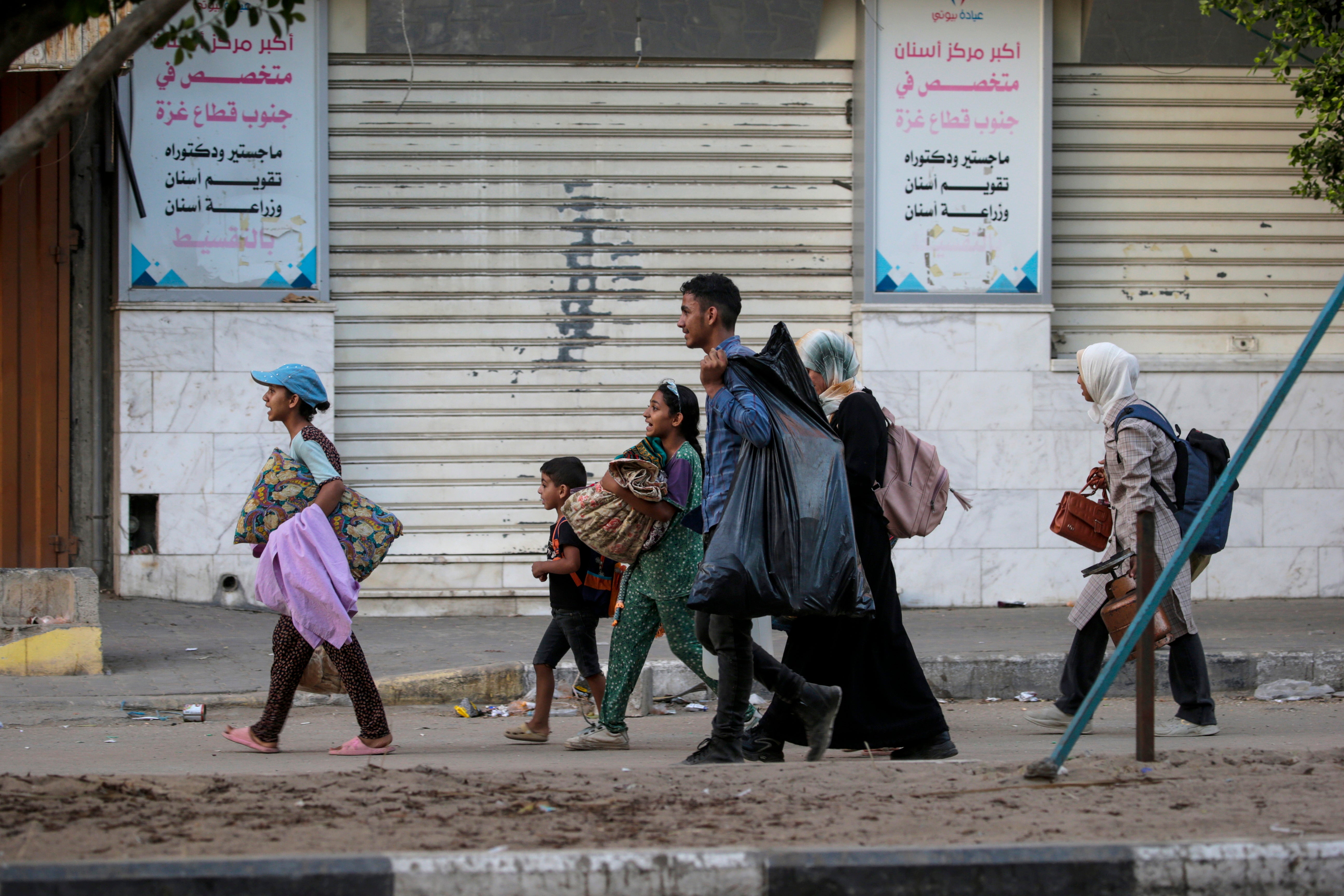 Internally displaced Palestinians, including women and children, flee during an Israeli military operation in Deir Al Balah, central Gaza Strip, 25 August 2024