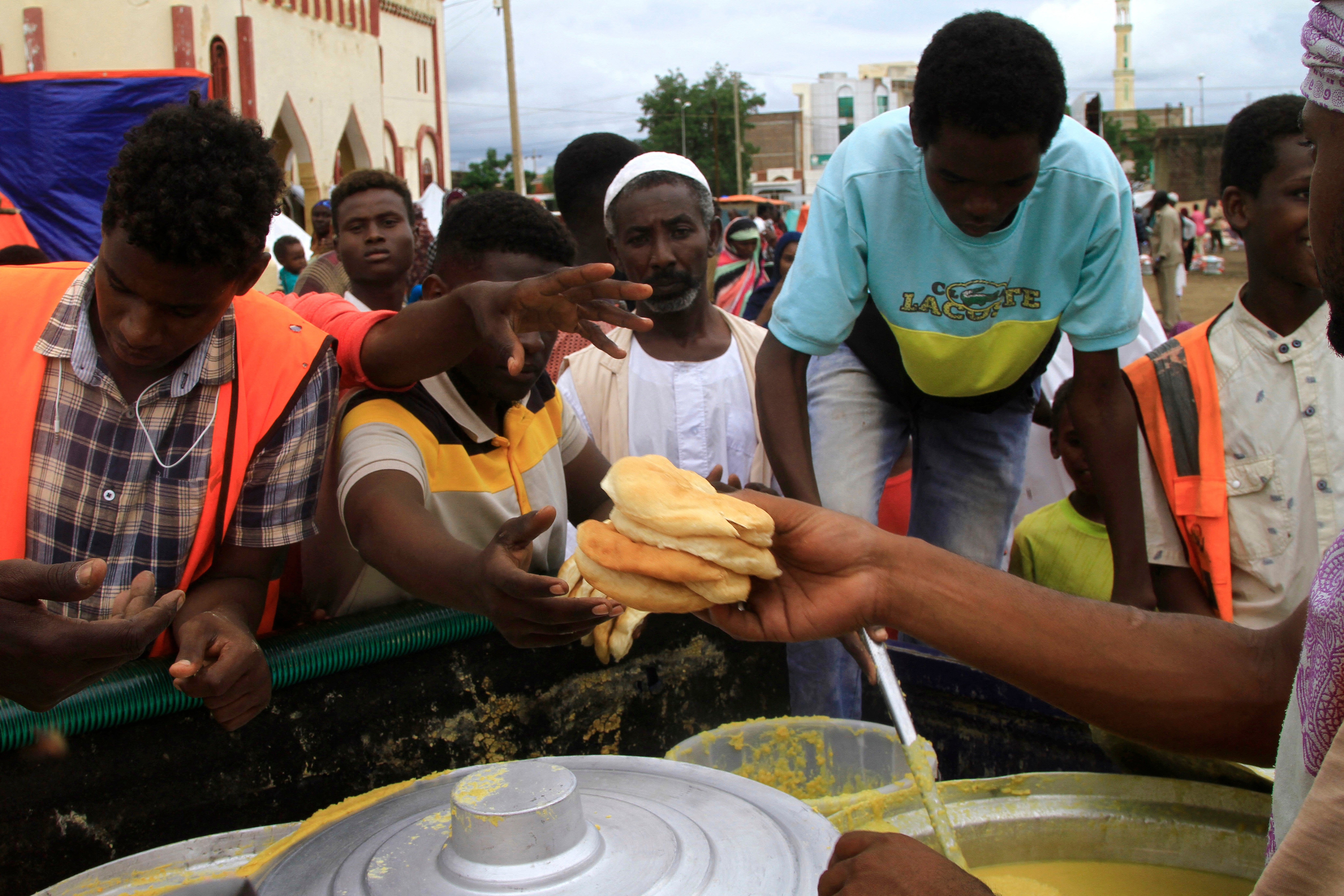 Displaced Sudanese queue to receive food portions at a makeshift camp in Gedaref, as the United Nations states that over 10 m have been displaced by the fighting in Sudan