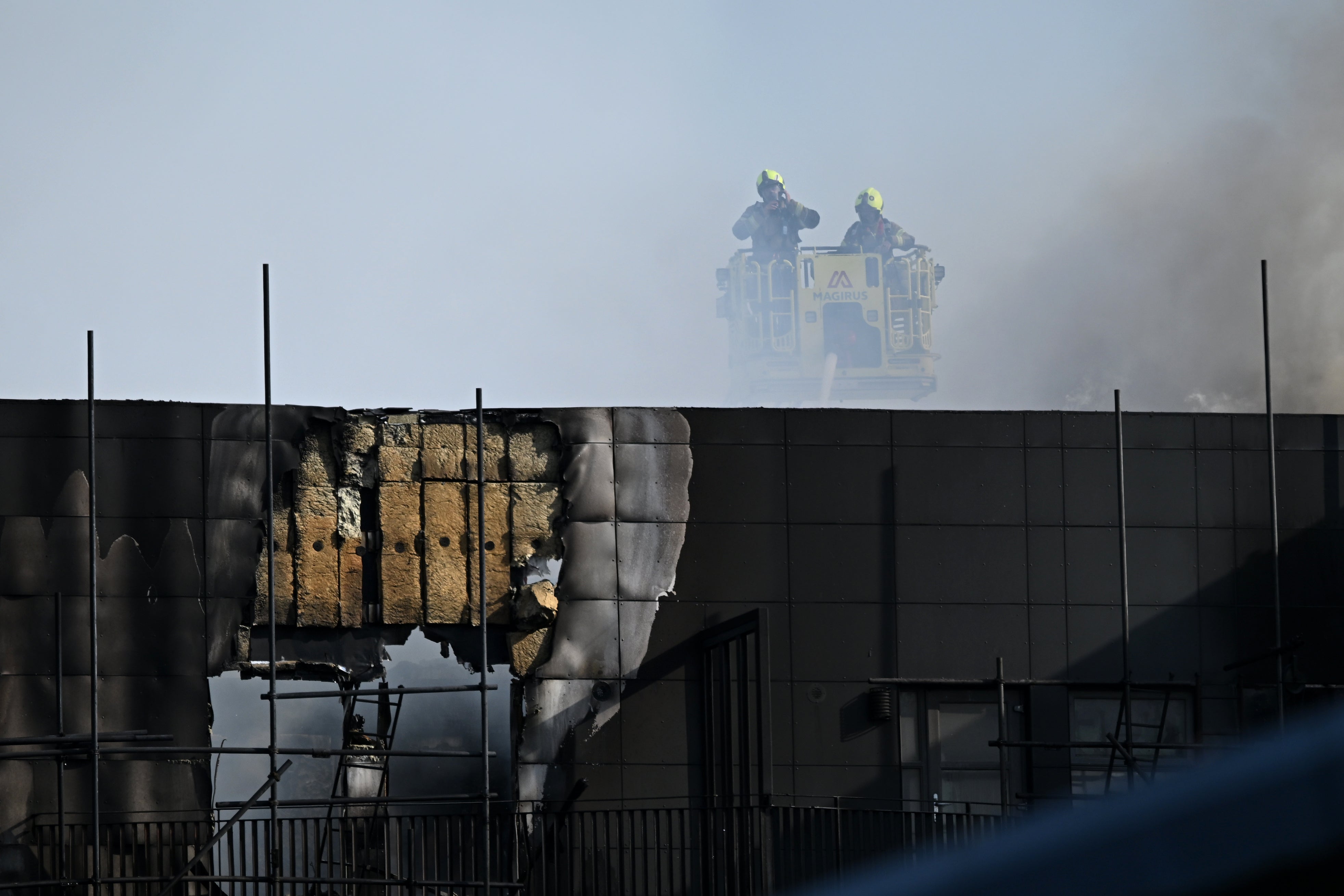 The charred exterior of a tower block in east London as firefighters tackle a huge fire