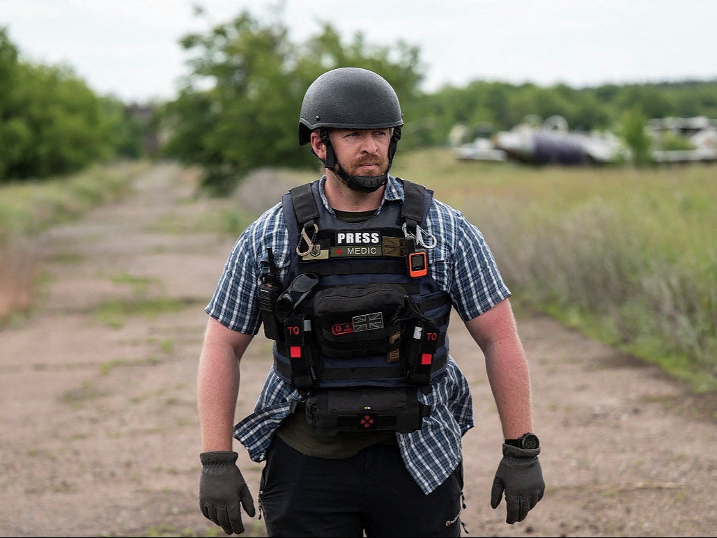 Reuters safety advisor Ryan Evans stands in a field while working with a news reporting team in an undated photo taken in Ukraine