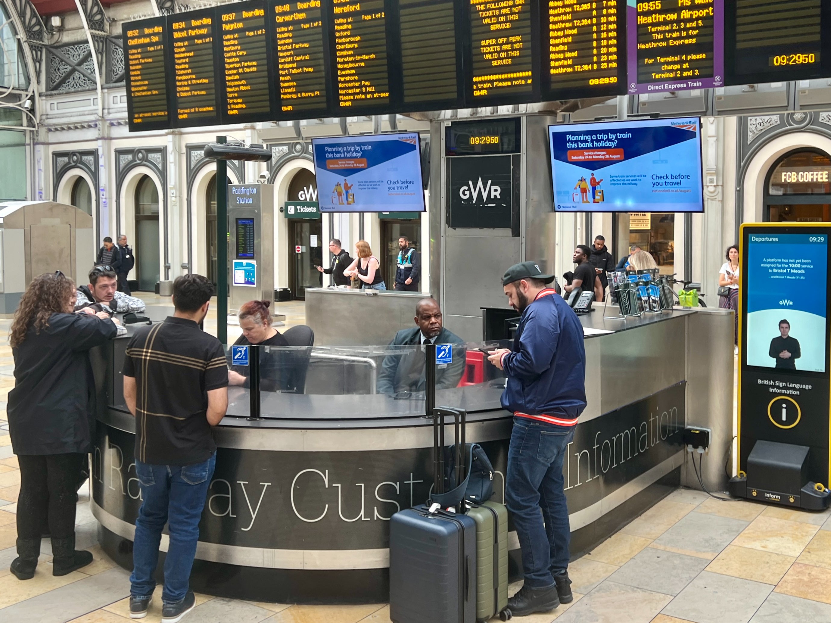 Helping hand: Passengers at London Paddington station information desk on Monday morning