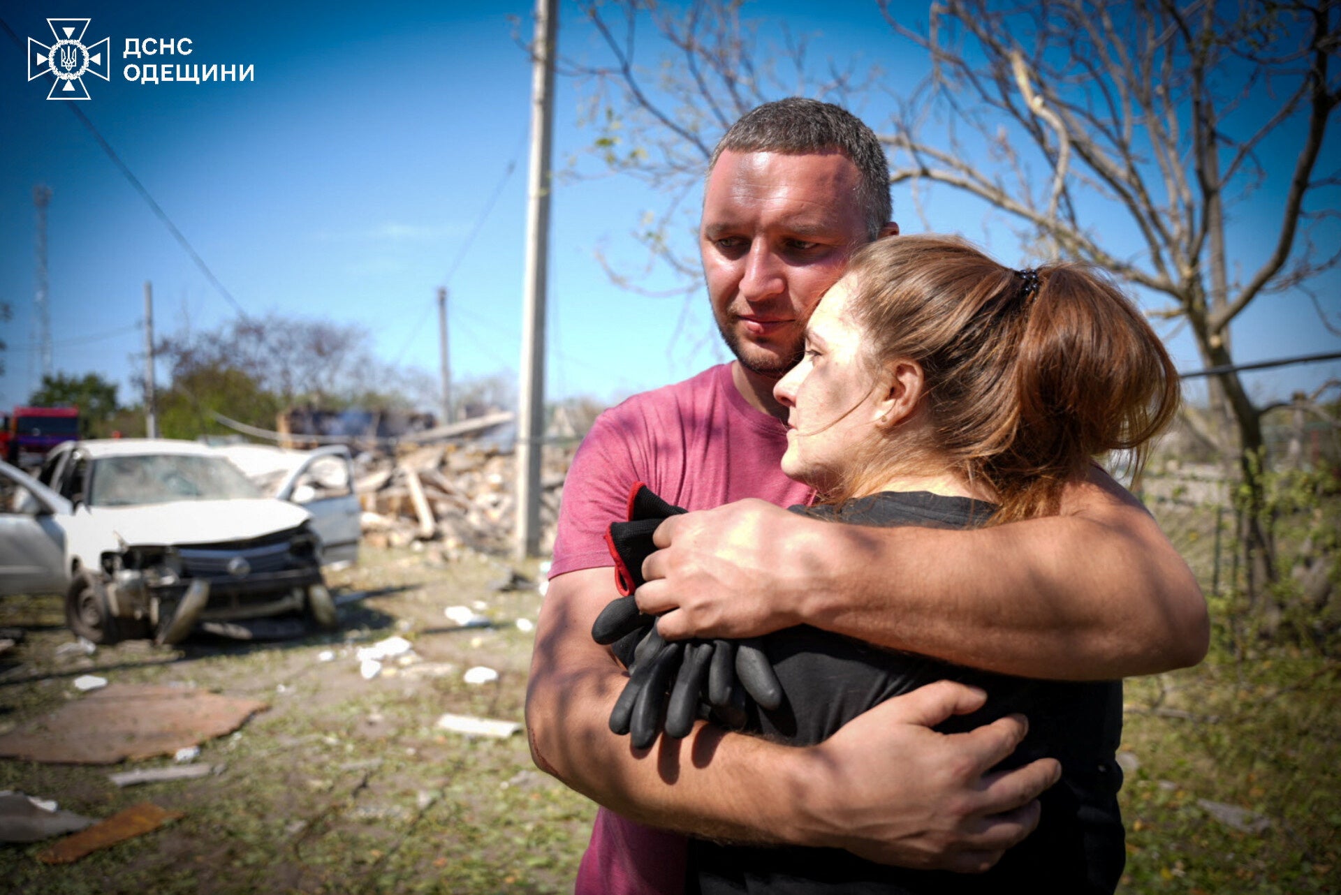 Local residents embrace each other at the site of a Russian missile strik in the Odesa region of Ukraine on Monday