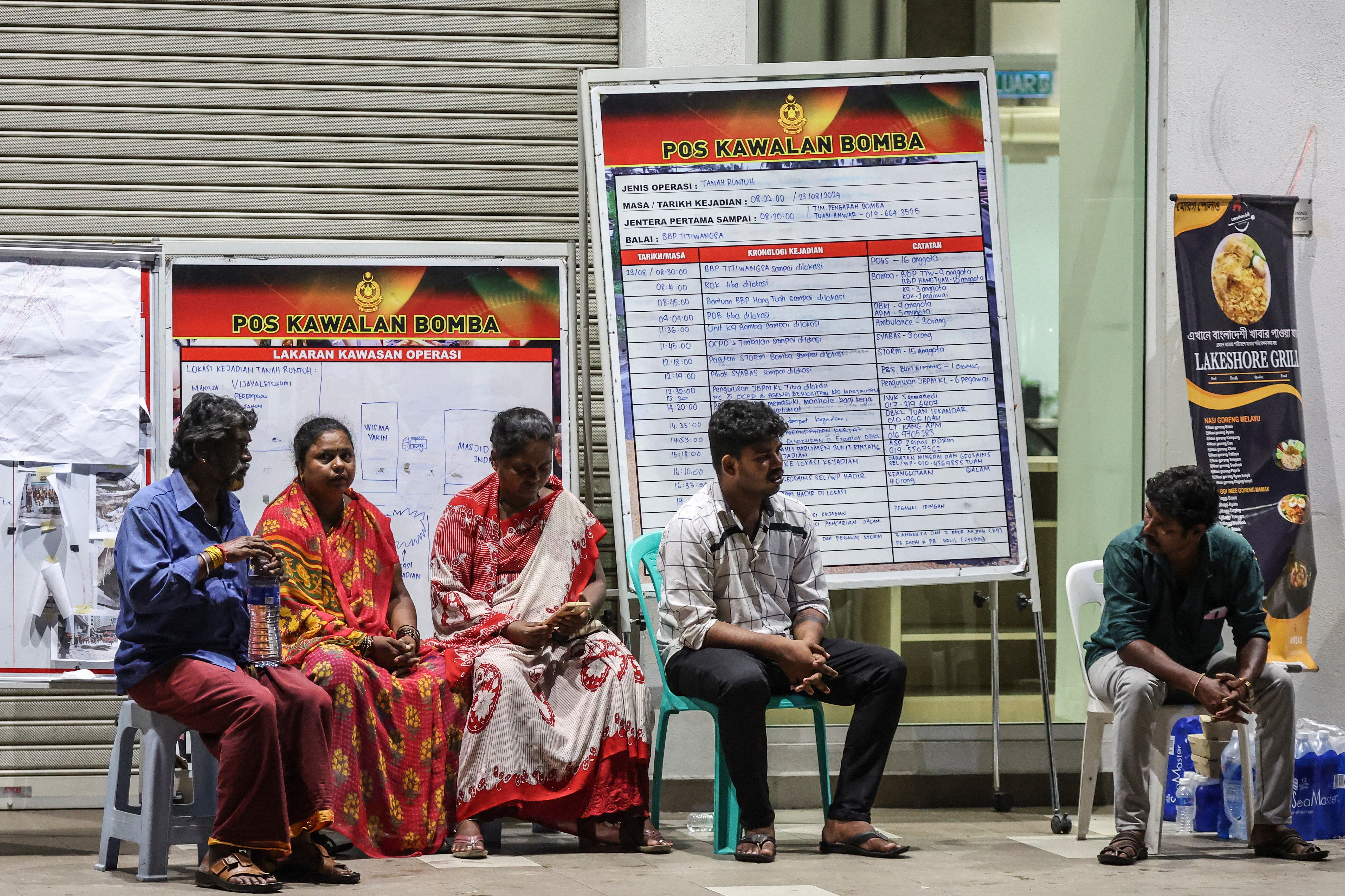 Relatives of an Indian woman who fell into an eight-meter deep sinkhole wait for news near the accident site