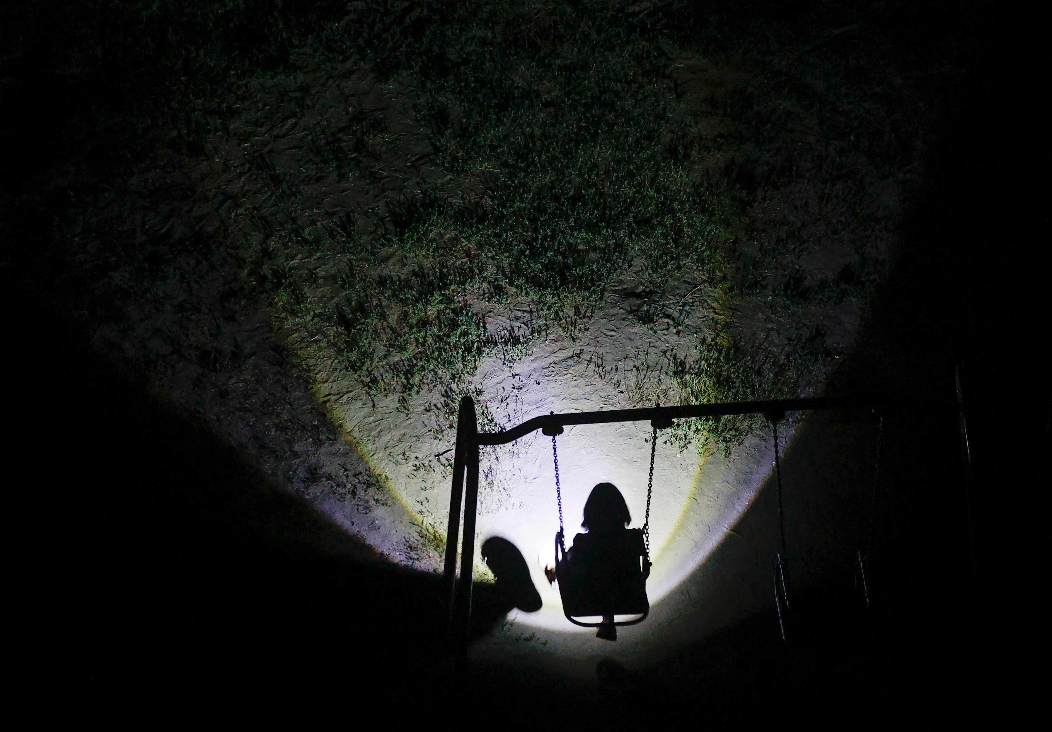 Children play in the dark with the aid of flashlights in a residential area during an electricity blackout in Kyiv, Ukraine, 26 August 2024