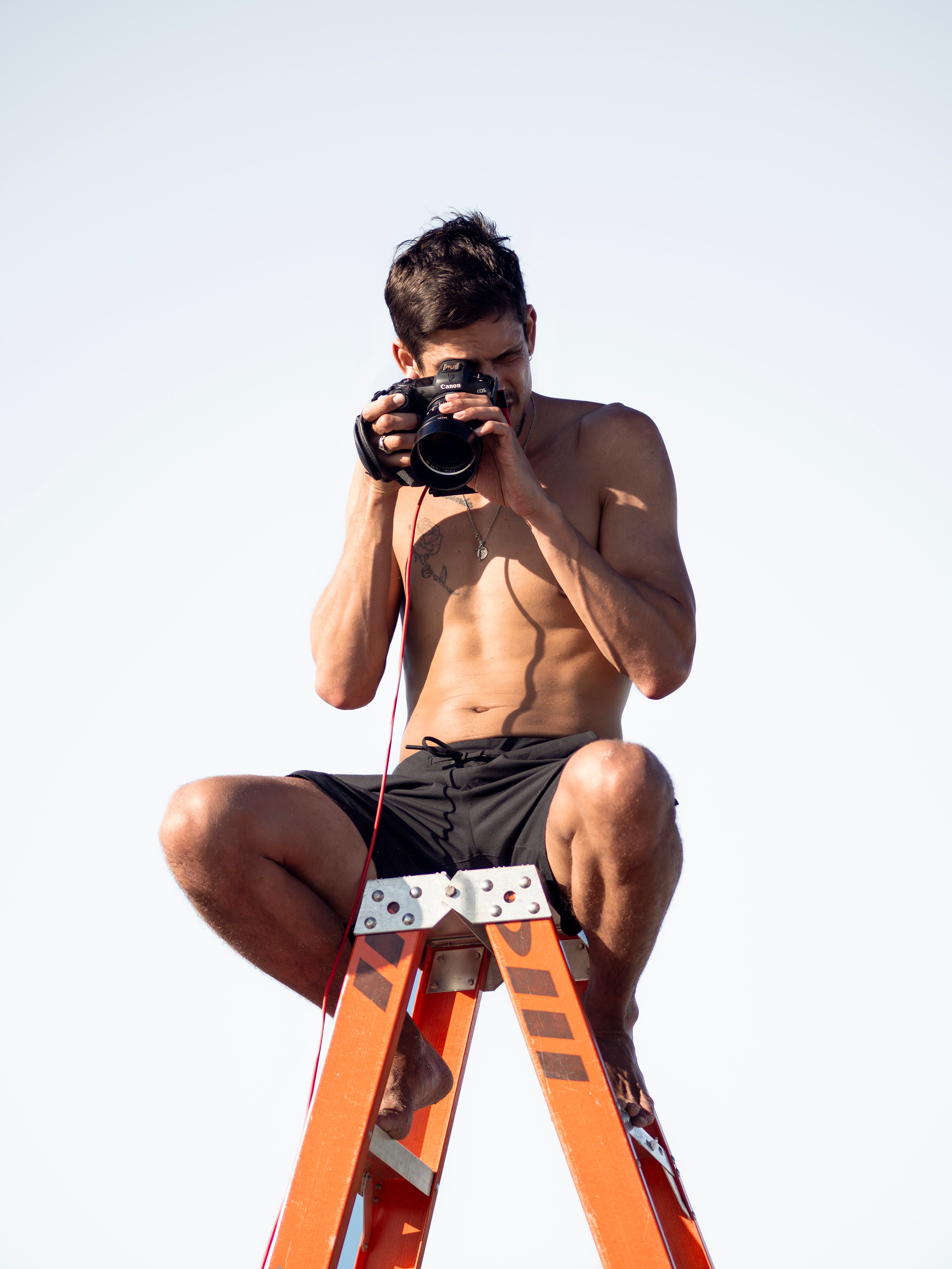 Ethan James Green balances on a ladder for Simone Ashley's 2025 Pirelli Calendar photo shoot