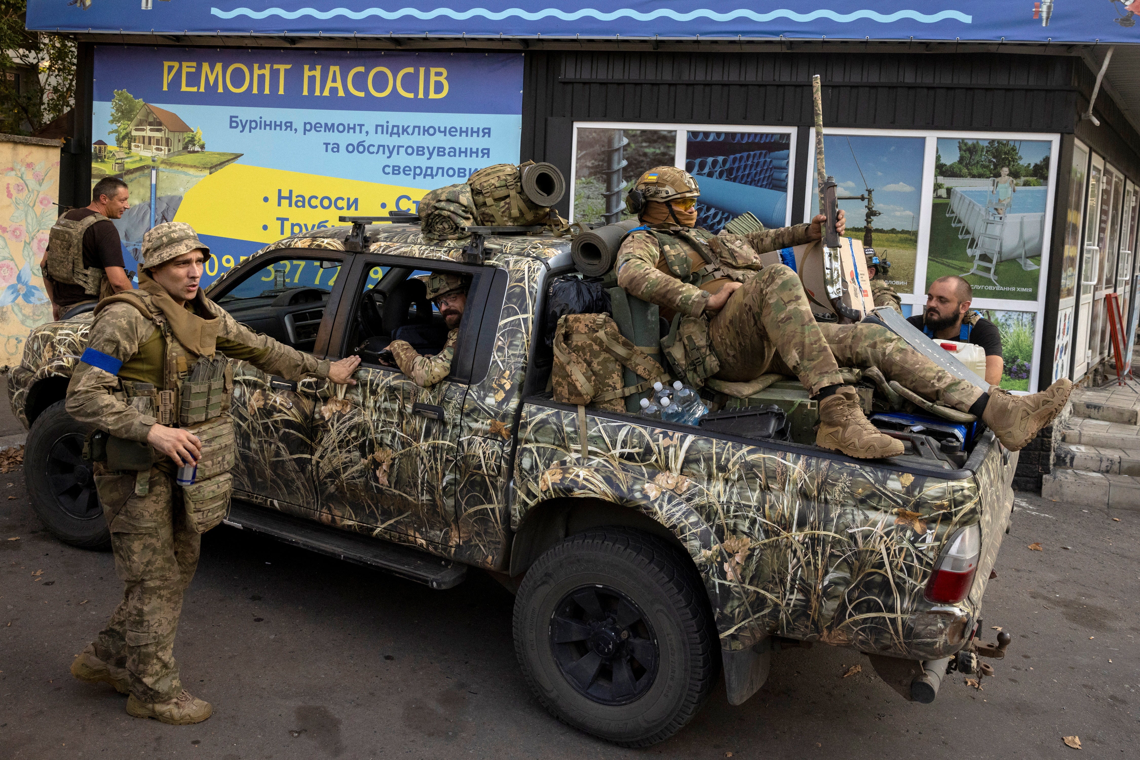 Ukrainische Soldaten versammeln sich um einen Pickup in Pokrowsk, Ukraine, während sie sich darauf vorbereiten, angesichts des russischen Angriffs auf die Ukraine in die Schlacht zu ziehen.