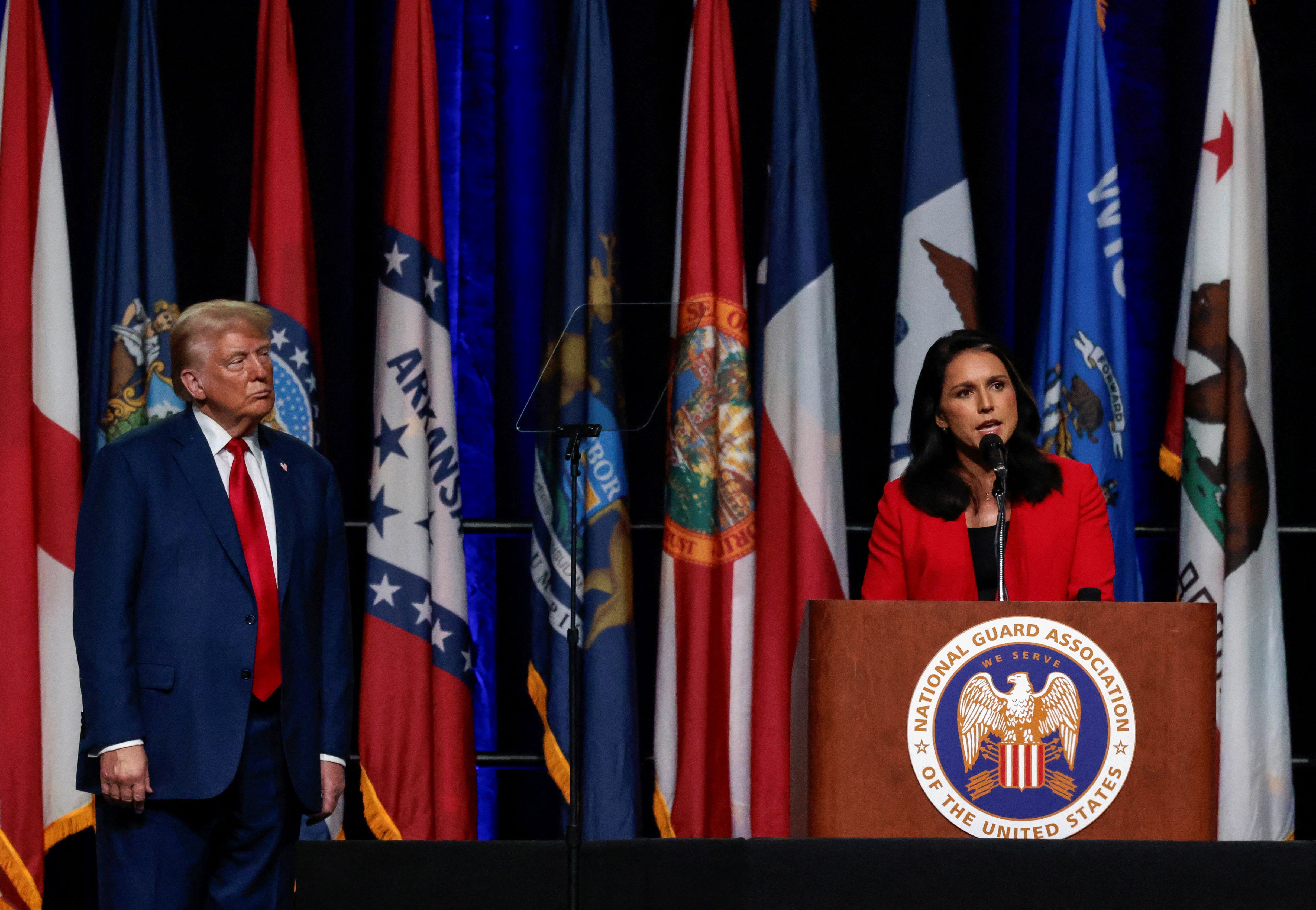 Republican presidential nominee and former U.S. President Donald Trump listens as former Democratic presidential candidate Tulsi Gabbard speaks at the National Guard of the United States NGAUS General Conference in Detroit, Michigan U.S., August 26, 2024