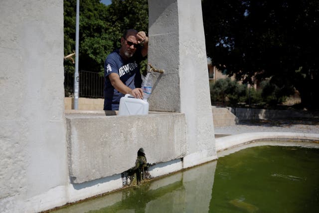 <p>Salvatore Celauro fills a container with water at a fountain following a drought on the Italian island of Sicily, in Agrigento, Italy, August 25</p>