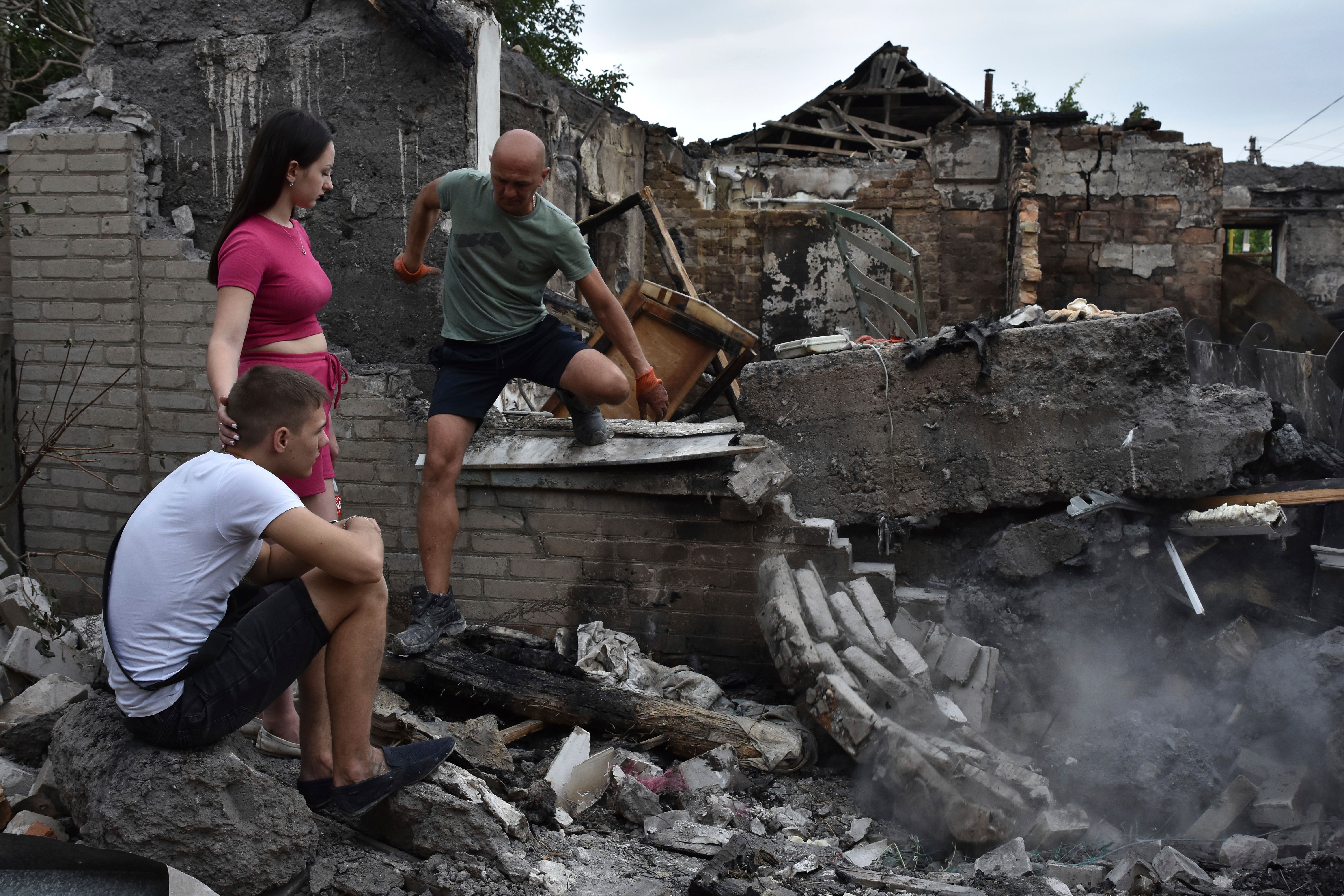 A couple sit in front of their house destroyed by a Russian strike in Zaporizhzhia, Ukraine