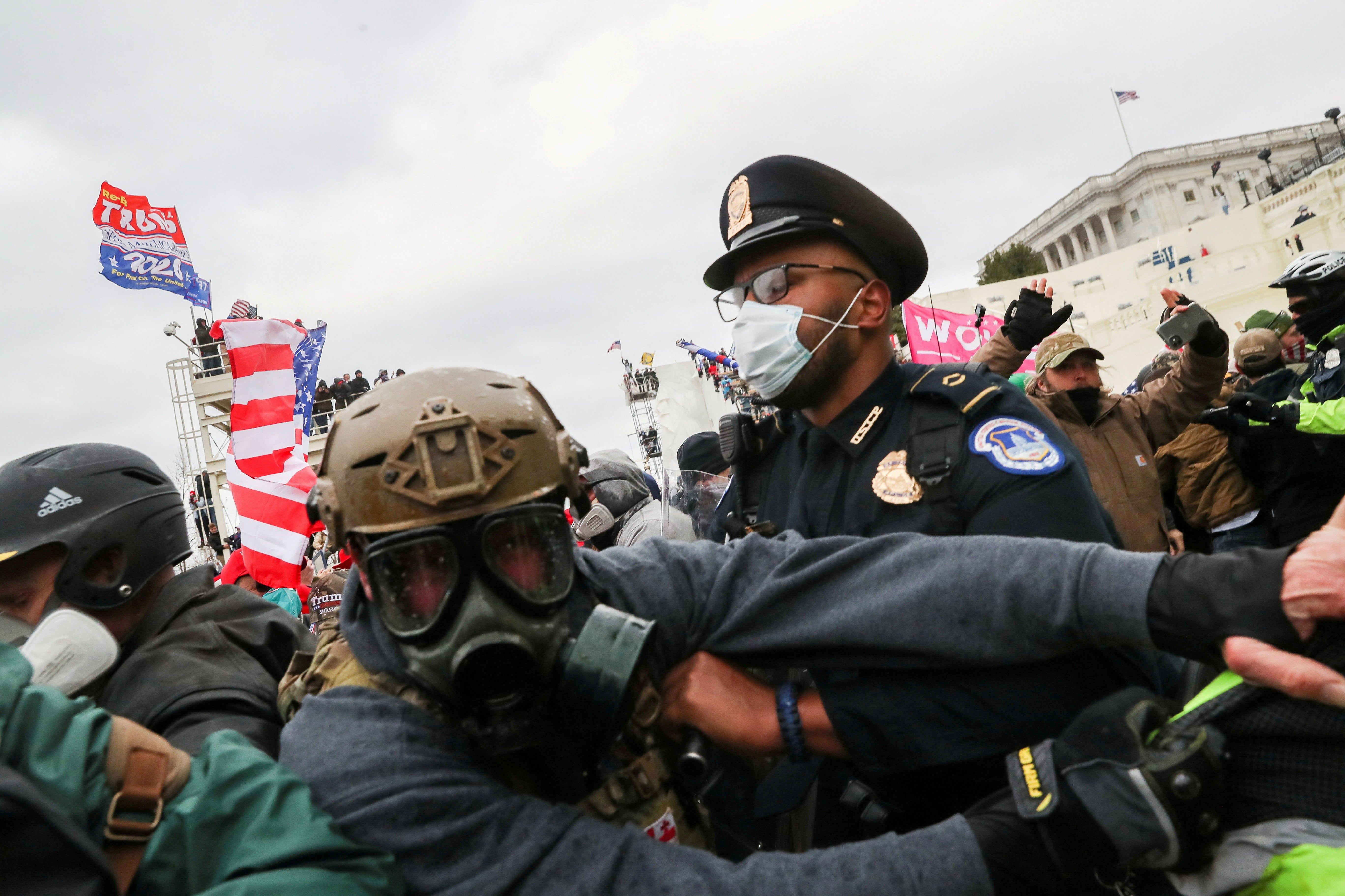 Un gruppo di sostenitori di Donald Trump tenta di violare le forze dell'ordine fuori dal Campidoglio il 6 gennaio 2021.