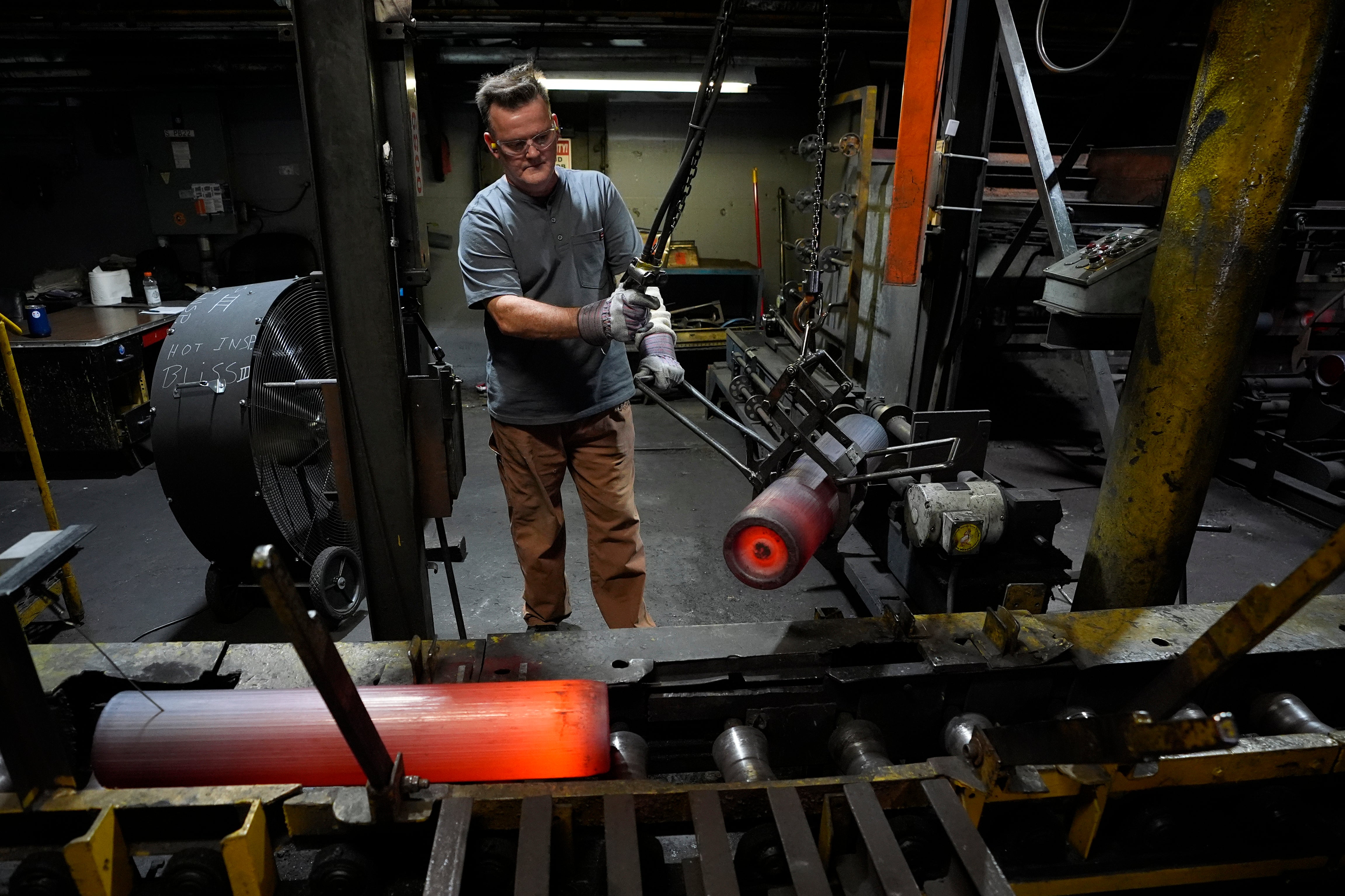 A steel worker moves heated 155 mm M795 artillery projectiles during the manufacturing process at the Scranton Army Ammunition Plant, Pennsylvania