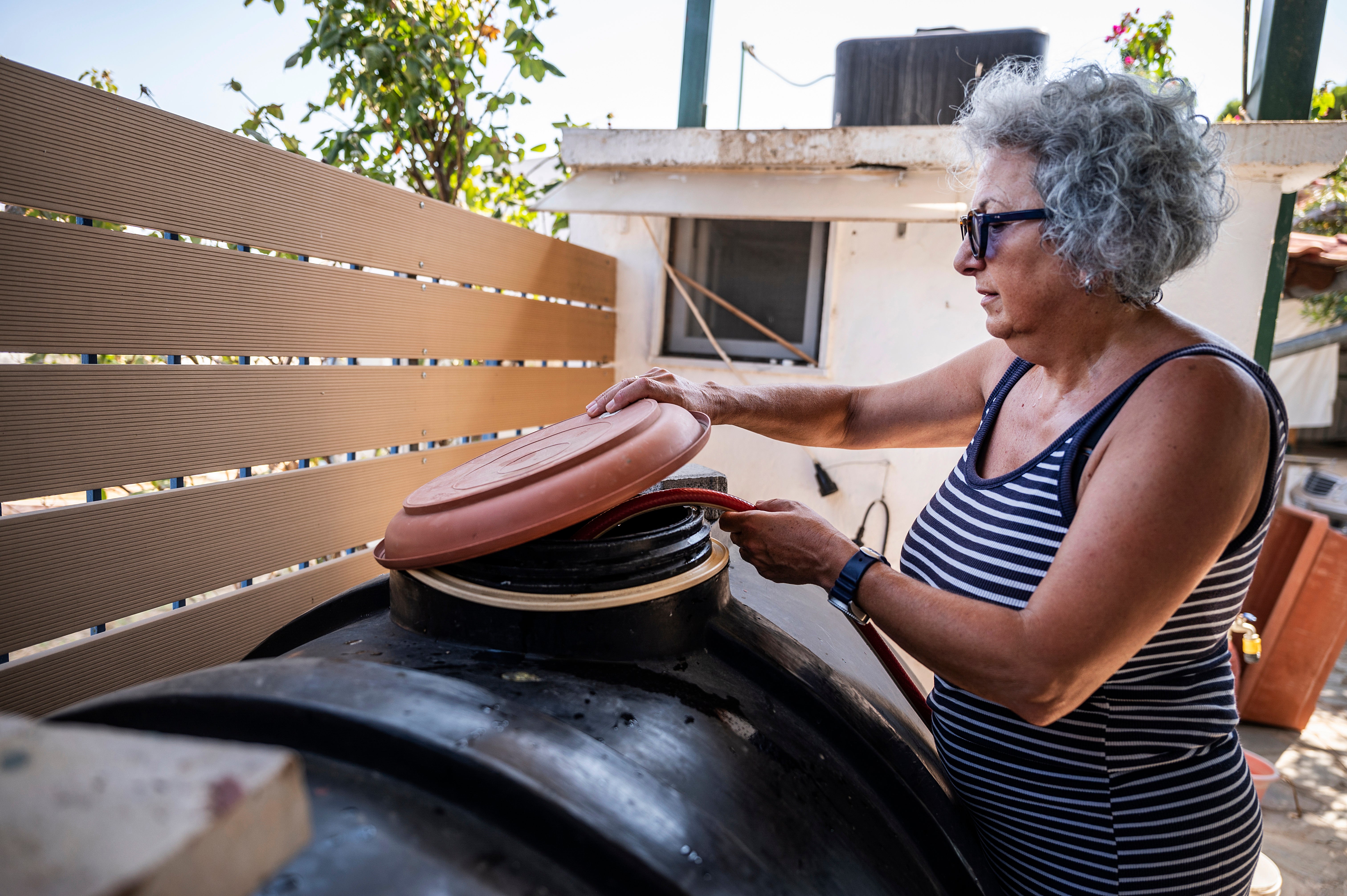 Haroula Psaropoulou, verifica o nível dentro de um tanque de água, na aldeia de Nea Potidea