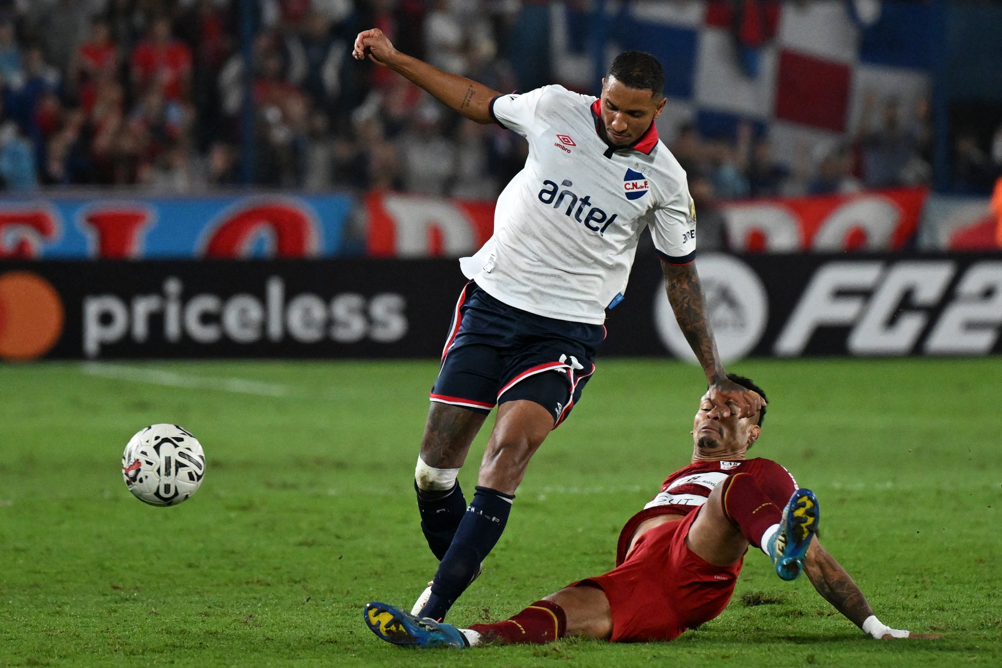 Nacional's defender Juan Manuel Izquierdo (L) fights for the ball during the Copa Libertadores third round