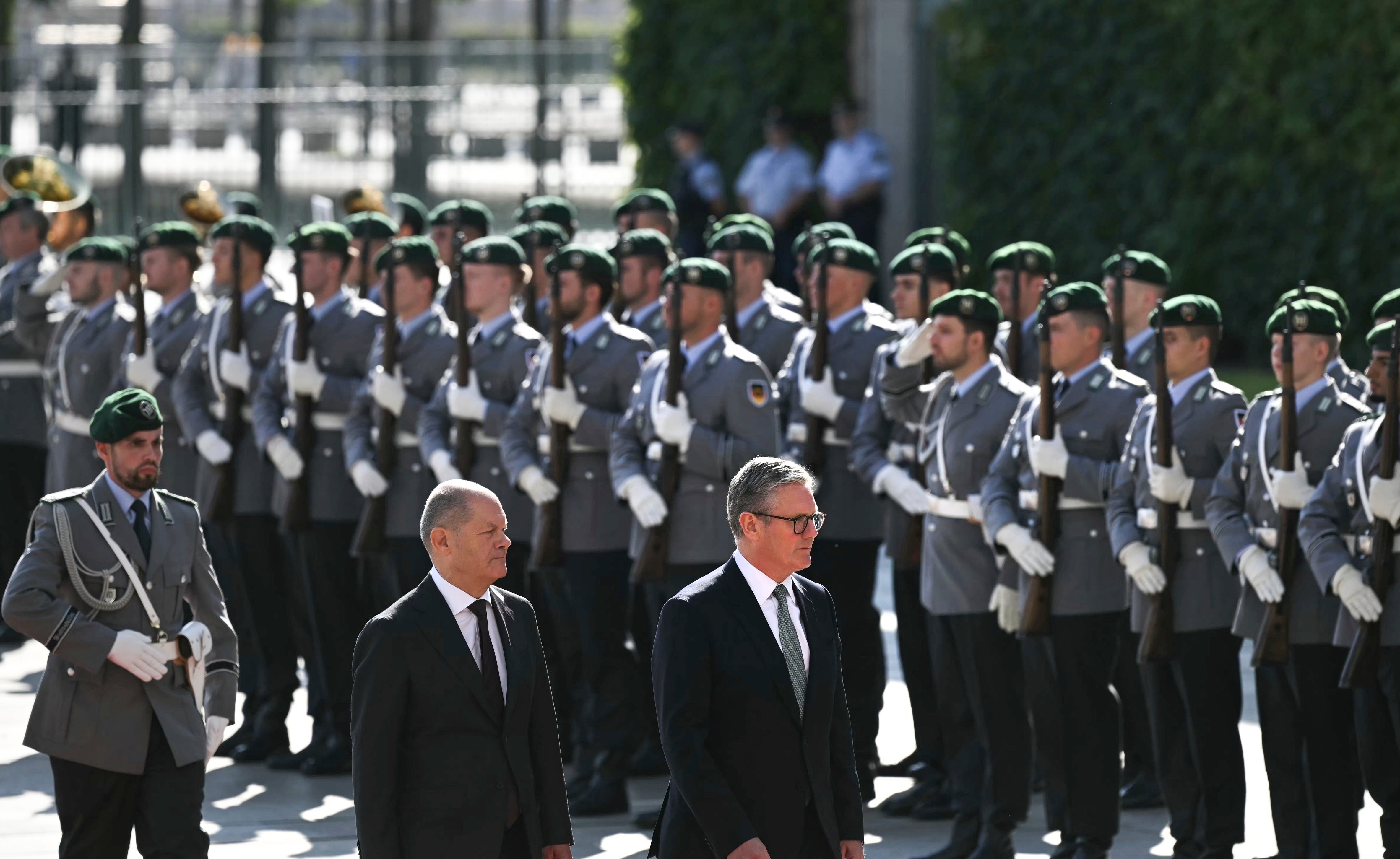 Bundeskanzler Olaf Scholz (links) und der britische Premierminister Keir Starmer begutachten während einer offiziellen Begrüßungszeremonie im Kanzleramt in Berlin eine militärische Ehrengarde