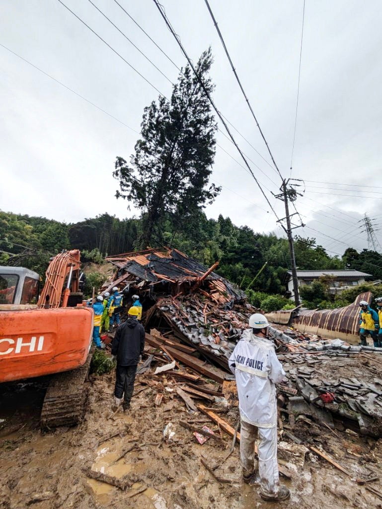 Rescue workers search for missing residents amid the ruins of a house in Gamagori, Aichi Prefecture