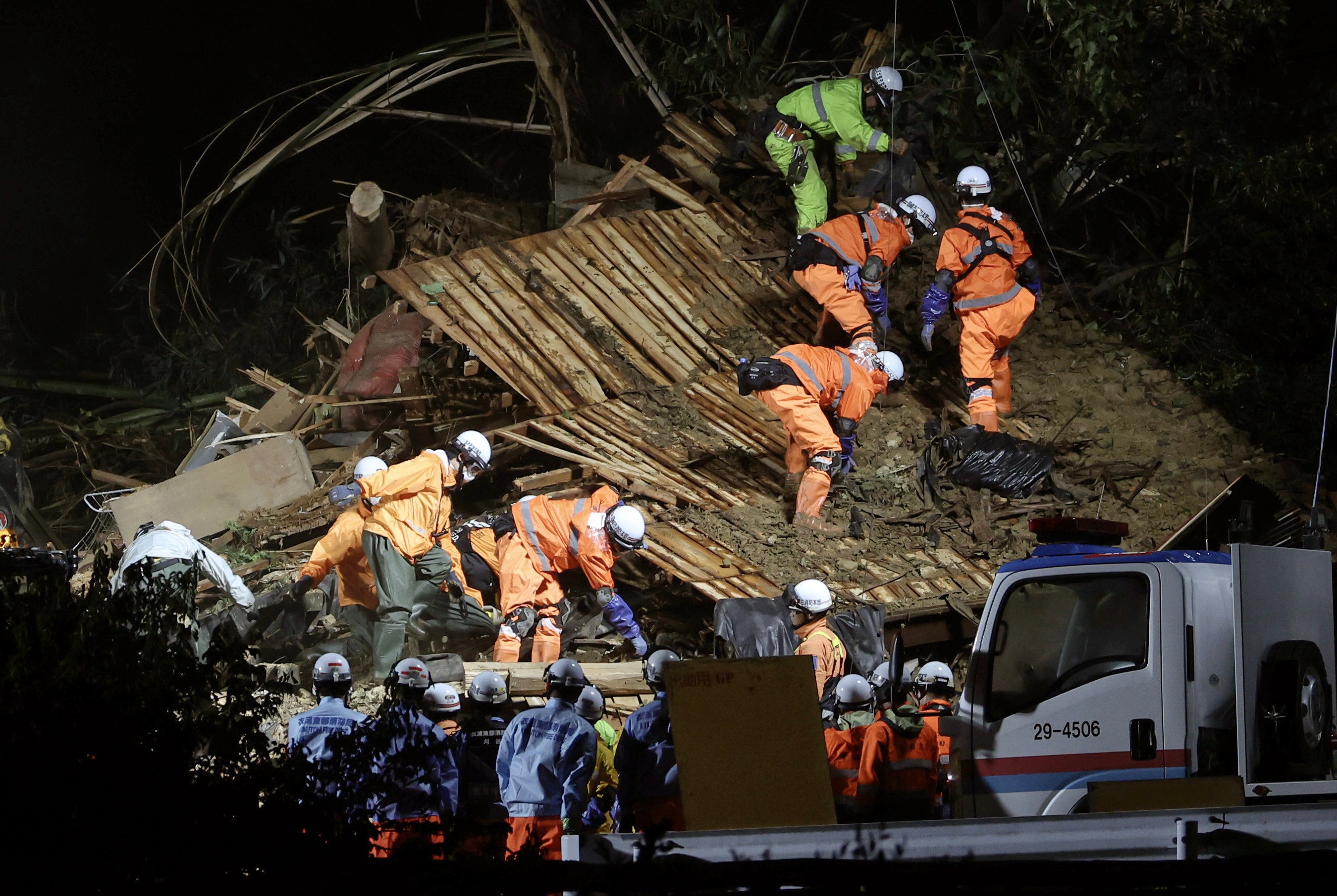 Rescue workers continue to search for missing residents amid the ruins of a house in Gamagori, Aichi Prefecture