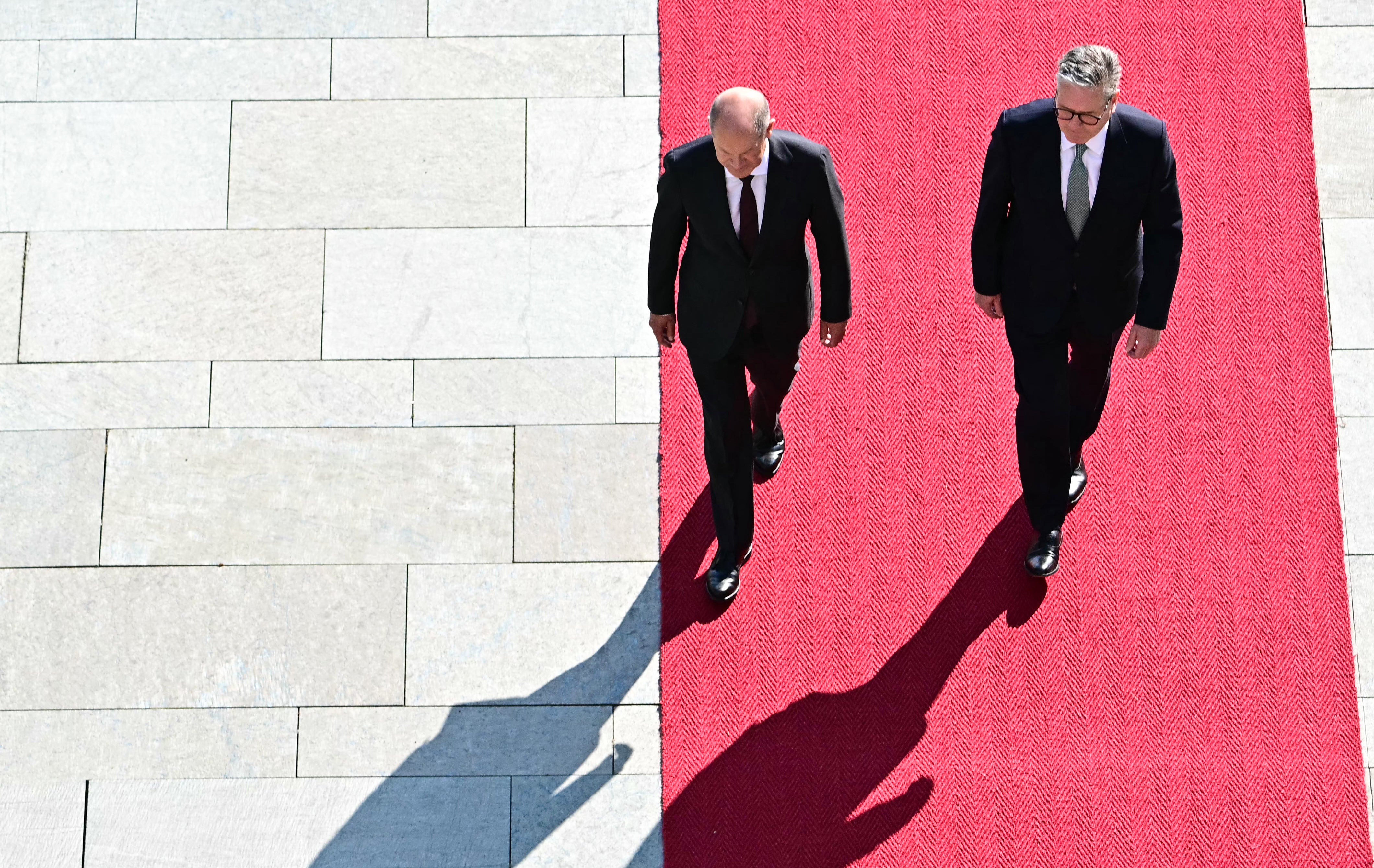 German Chancellor Olaf Scholz (L) welcomes Britain's Prime Minister Keir Starmer during an official welcome ceremony at the Chancellery in Berlin