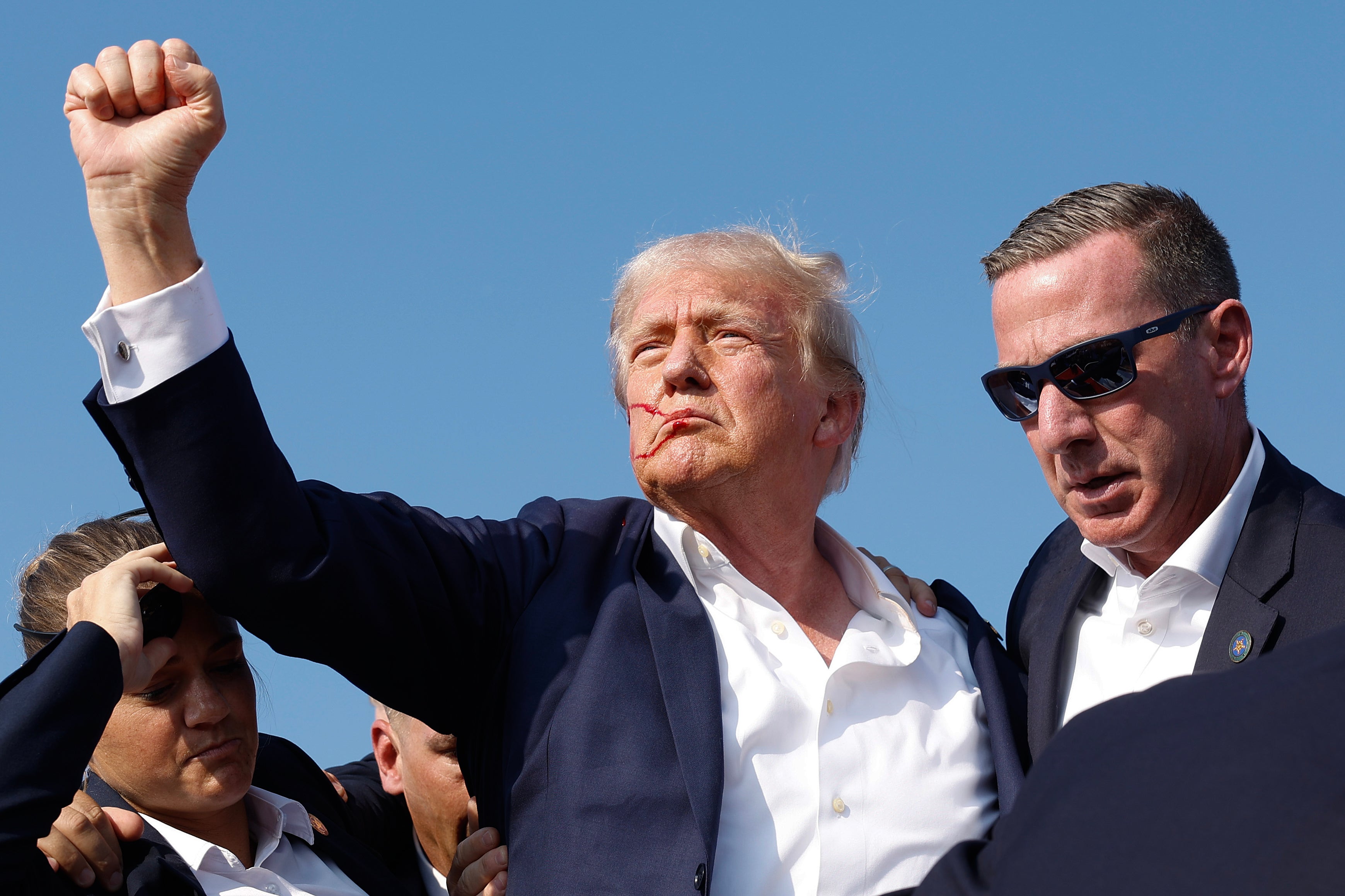 Donald Trump pumps his fist as he is rushed offstage during a rally on July 13, 2024, in Butler, Pennsylvania. New photos of the rifle used in the shooting have been released by the FBI.