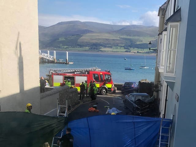 <p>Emergency services at the scene at Alma Street in Beaumaris on Anglesey, where three people have died following a road collision</p>