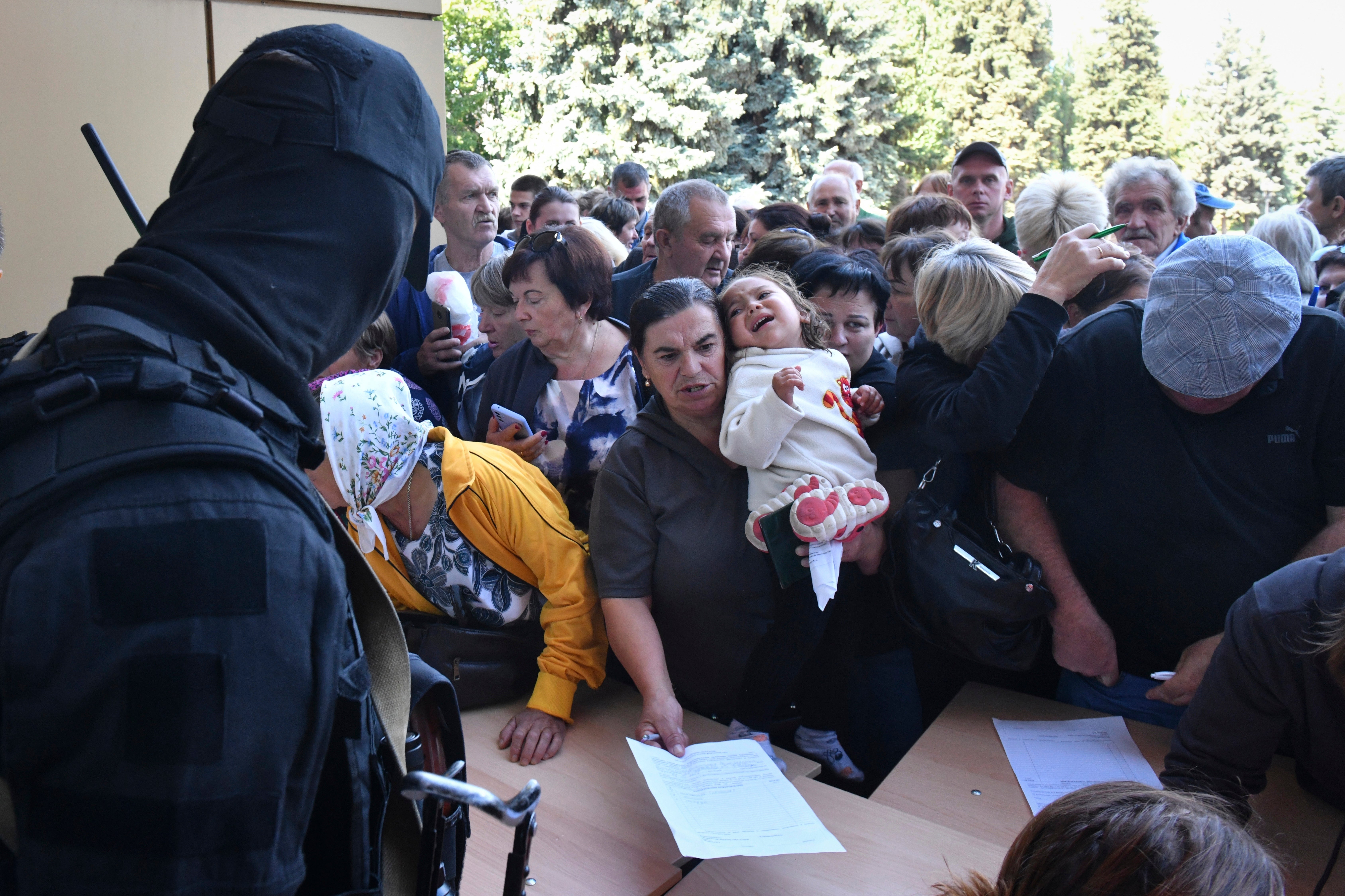 Evacuees line up to fill out forms at a humanitarian aid distribution center in Kursk, Russia