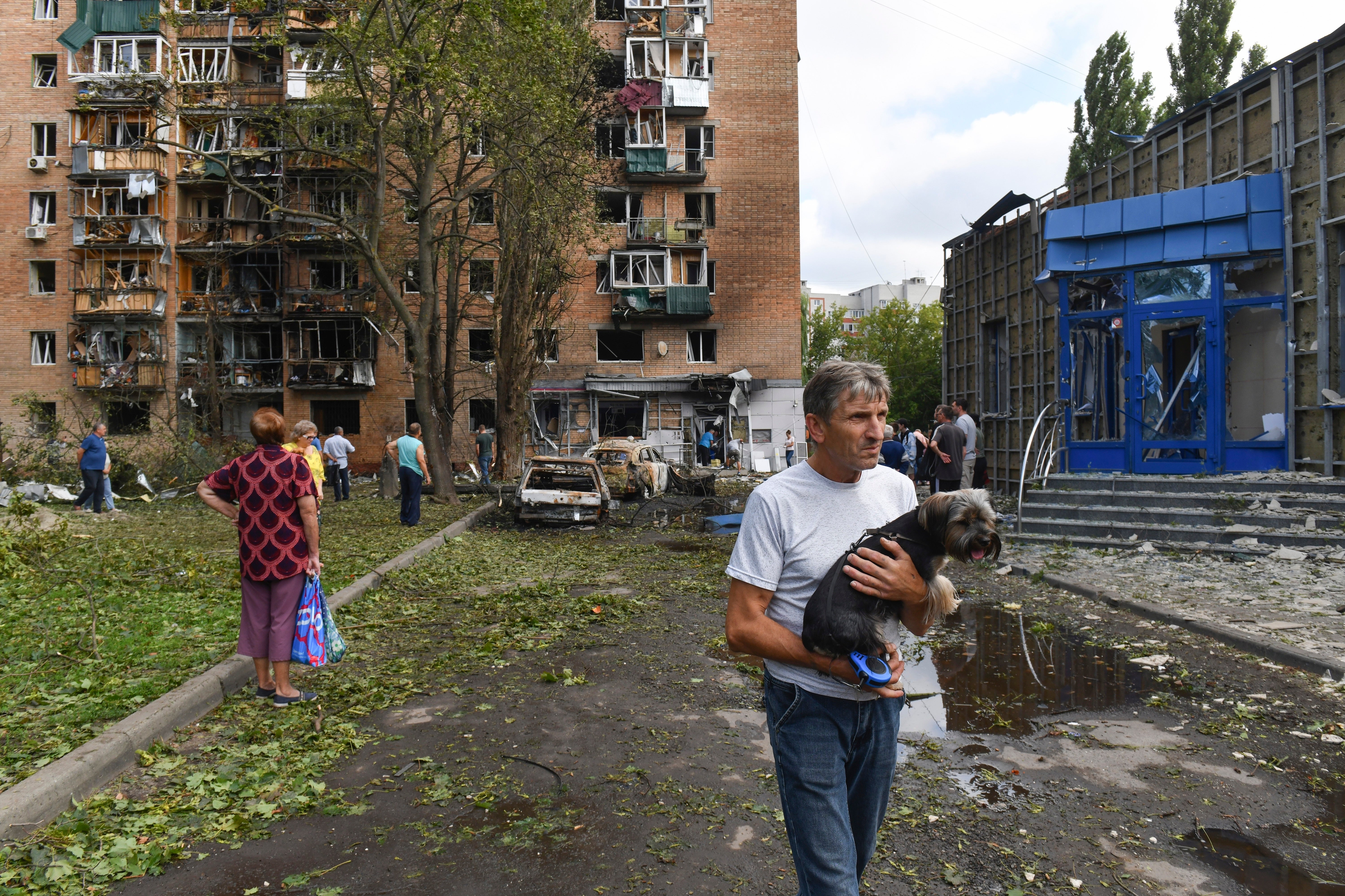 Shock and awe: Residents leave an apartment building in Kursk that has been damaged in shelling by Ukrainian forces