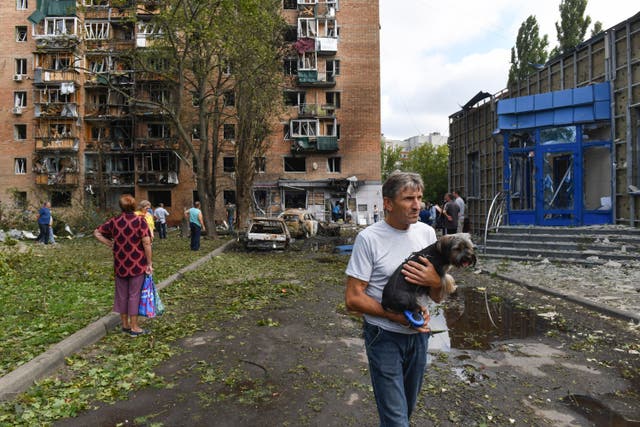 <p>Shock and awe: Residents leave an apartment building in Kursk that has been damaged in shelling by Ukrainian forces</p>