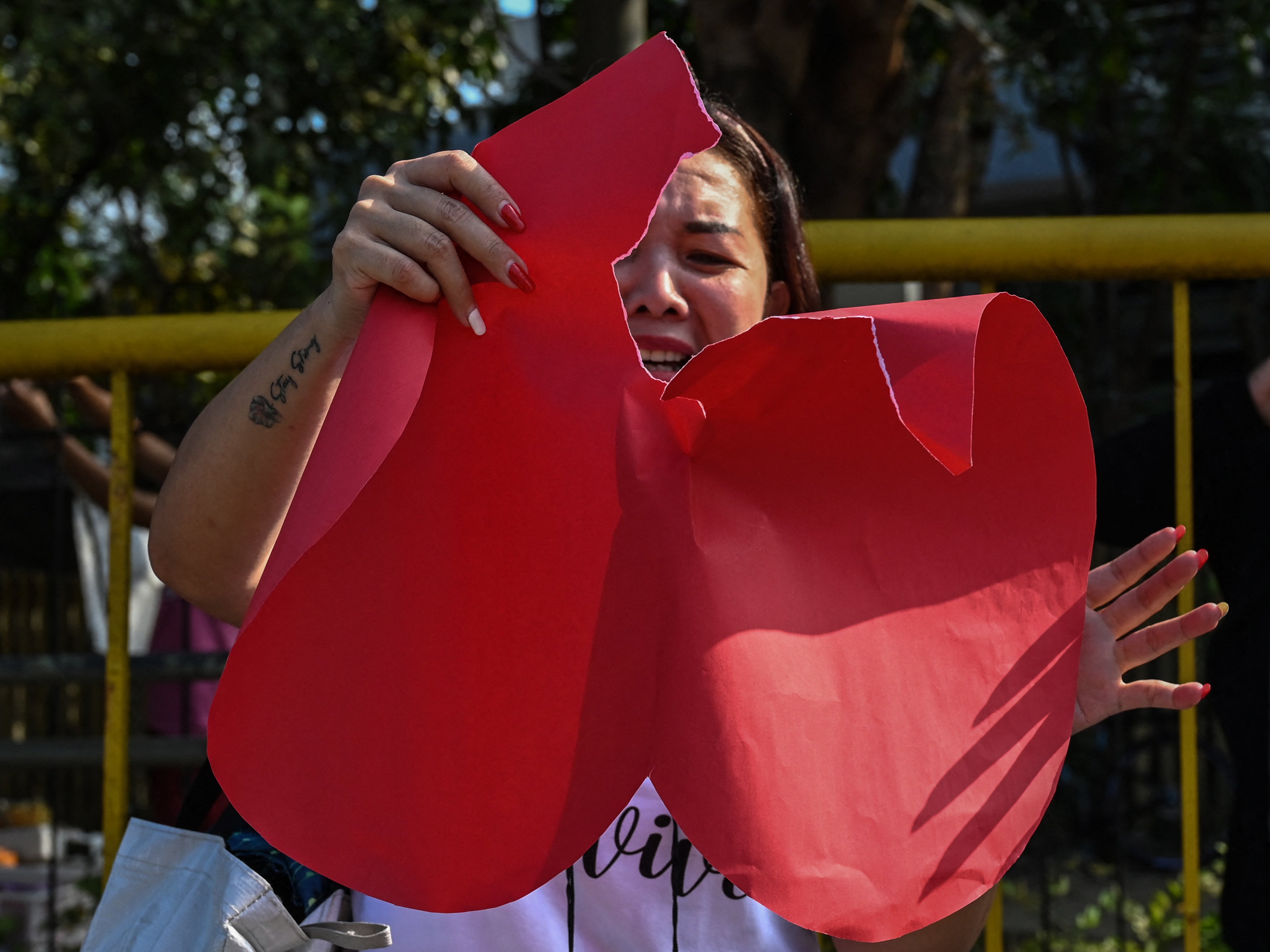 A pro-divorce protester tears a heart-shaped piece of paper during a demonstration