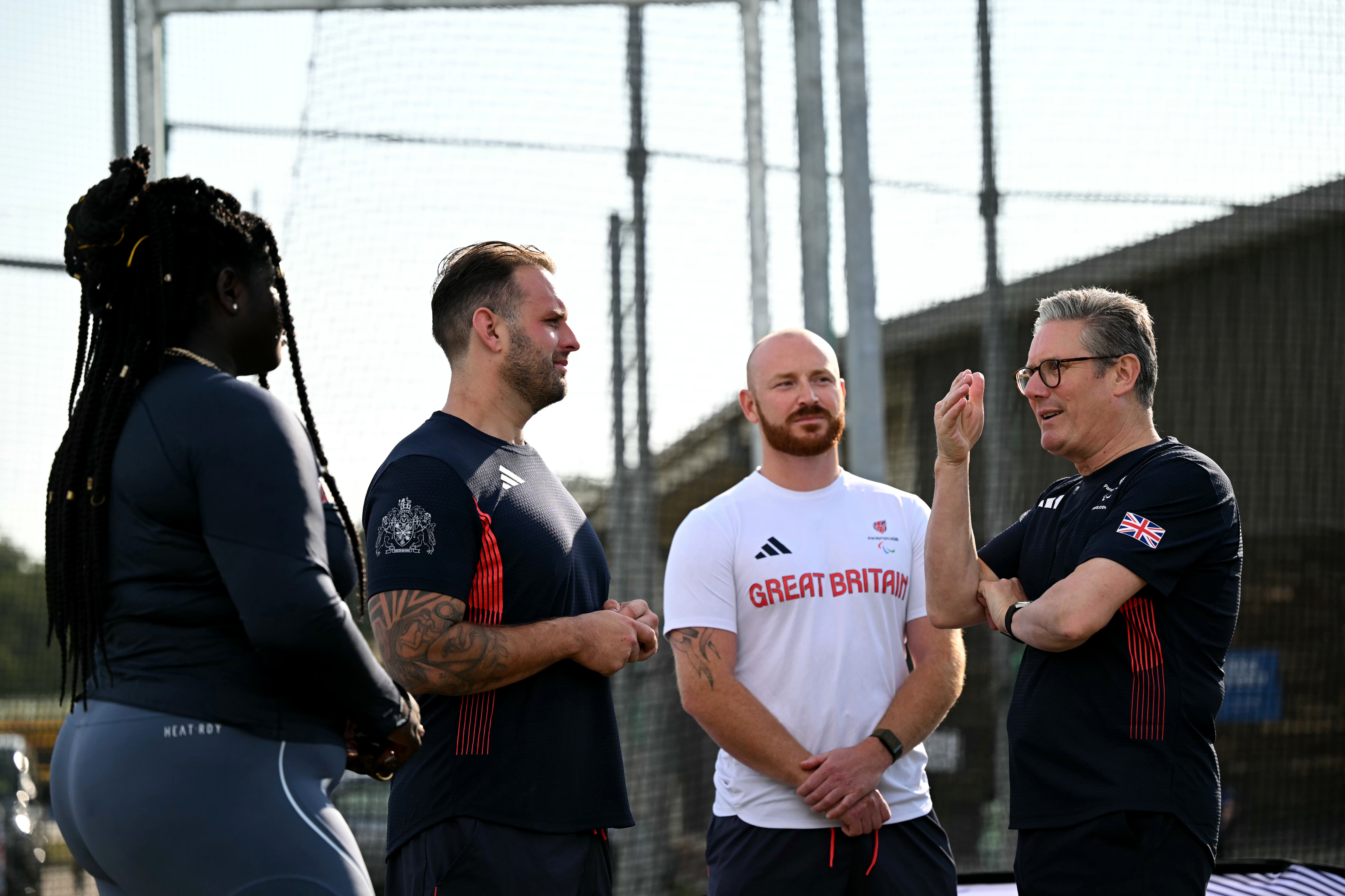 Keir Starmer (R) speaks with British athletes Daniel Pembroke (2-R), Aled Davies (2-L) and Funmi Oduwaiye (L) during a visit at a training centre in Saint-Germain-en-Laye, north-west of Paris