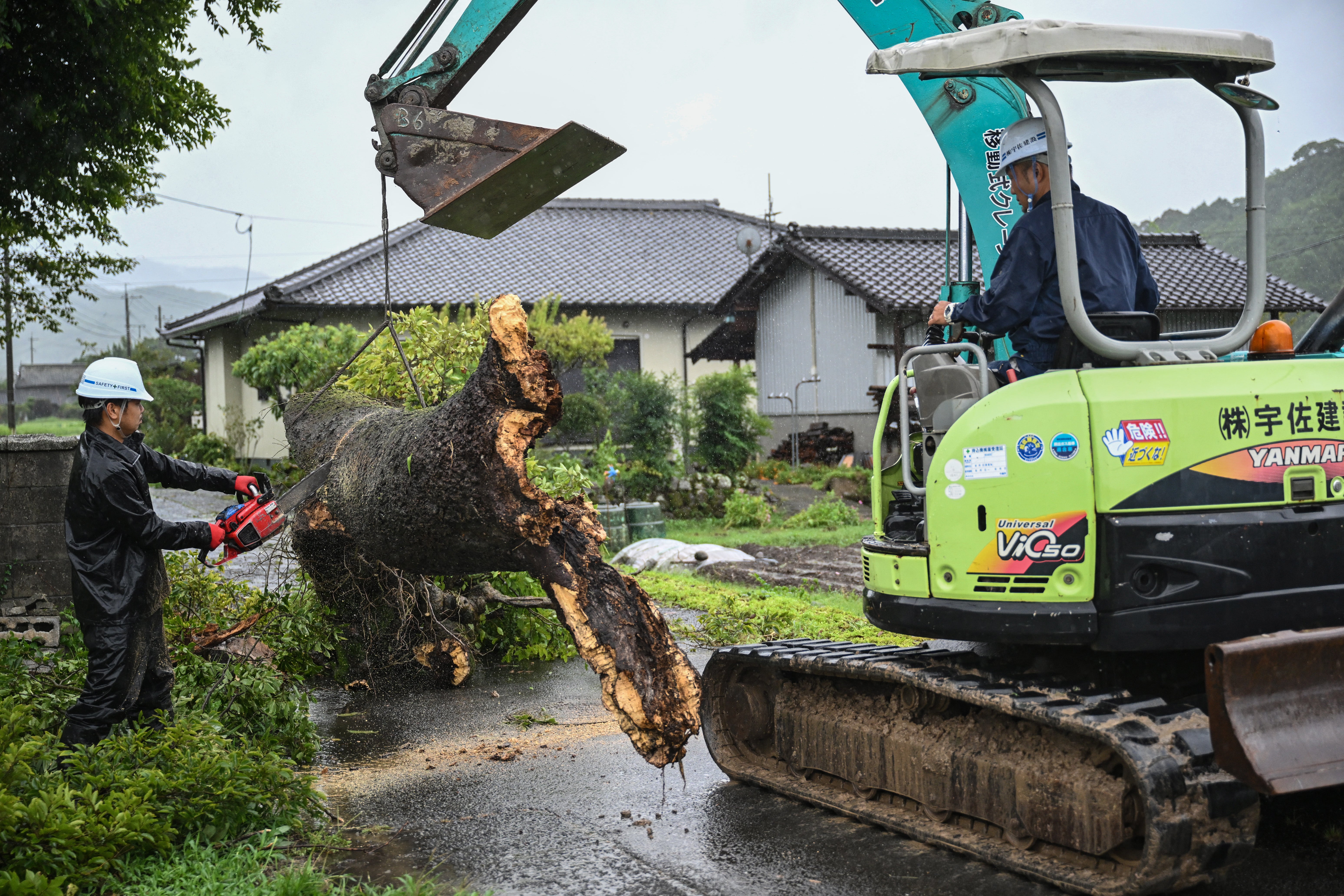 Workers remove a fallen tree brought down by strong winds from Typhoon Shanshan in Usa, Oita prefecture