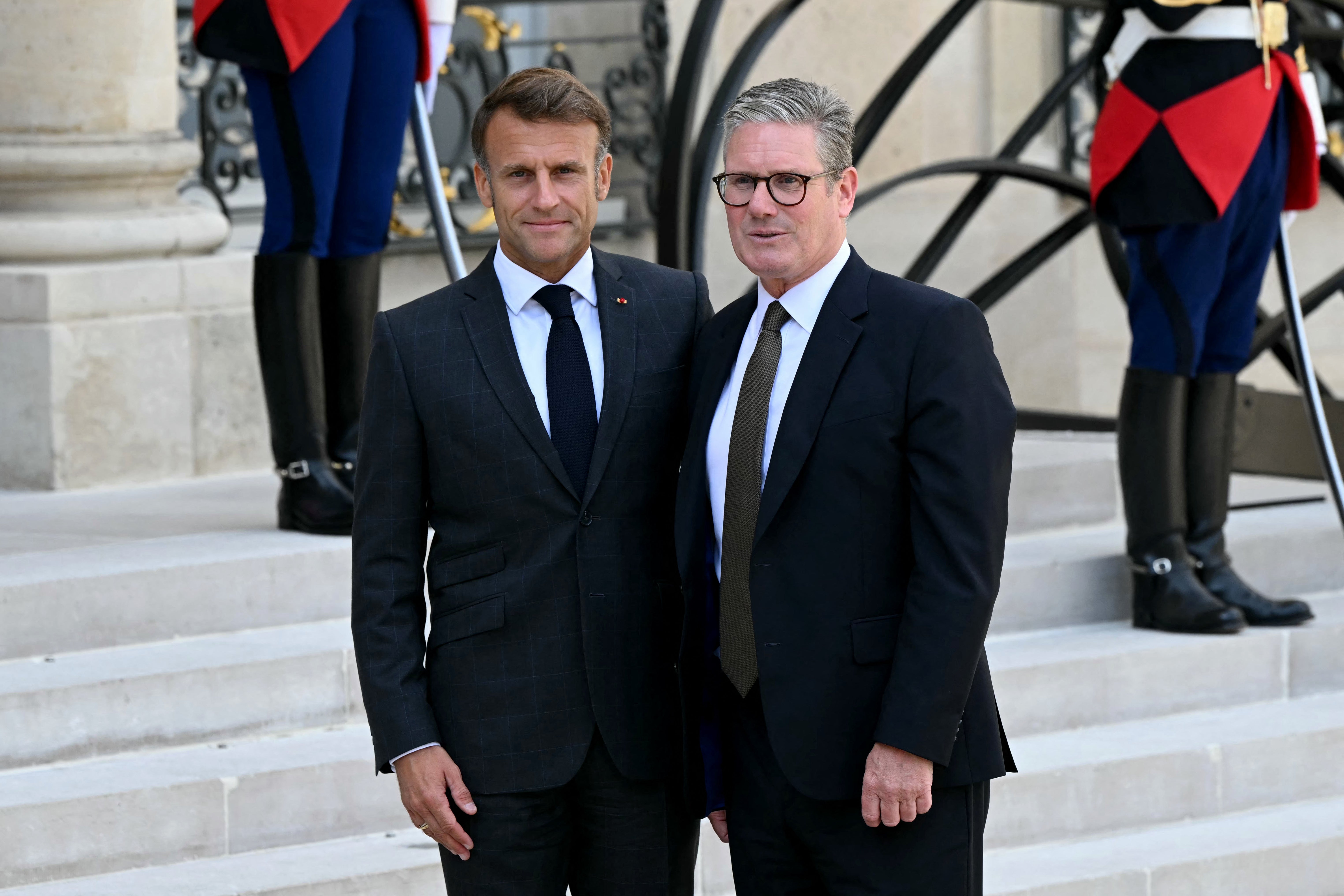 France's President Emmanuel Macron (L) greets Britain's Prime Minister Keir Starmer (R) as he arrives at the Elysee presidential palace