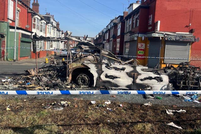 A burnt out car in the Leeds suburb of Harehills (Katie Dickinson/PA)