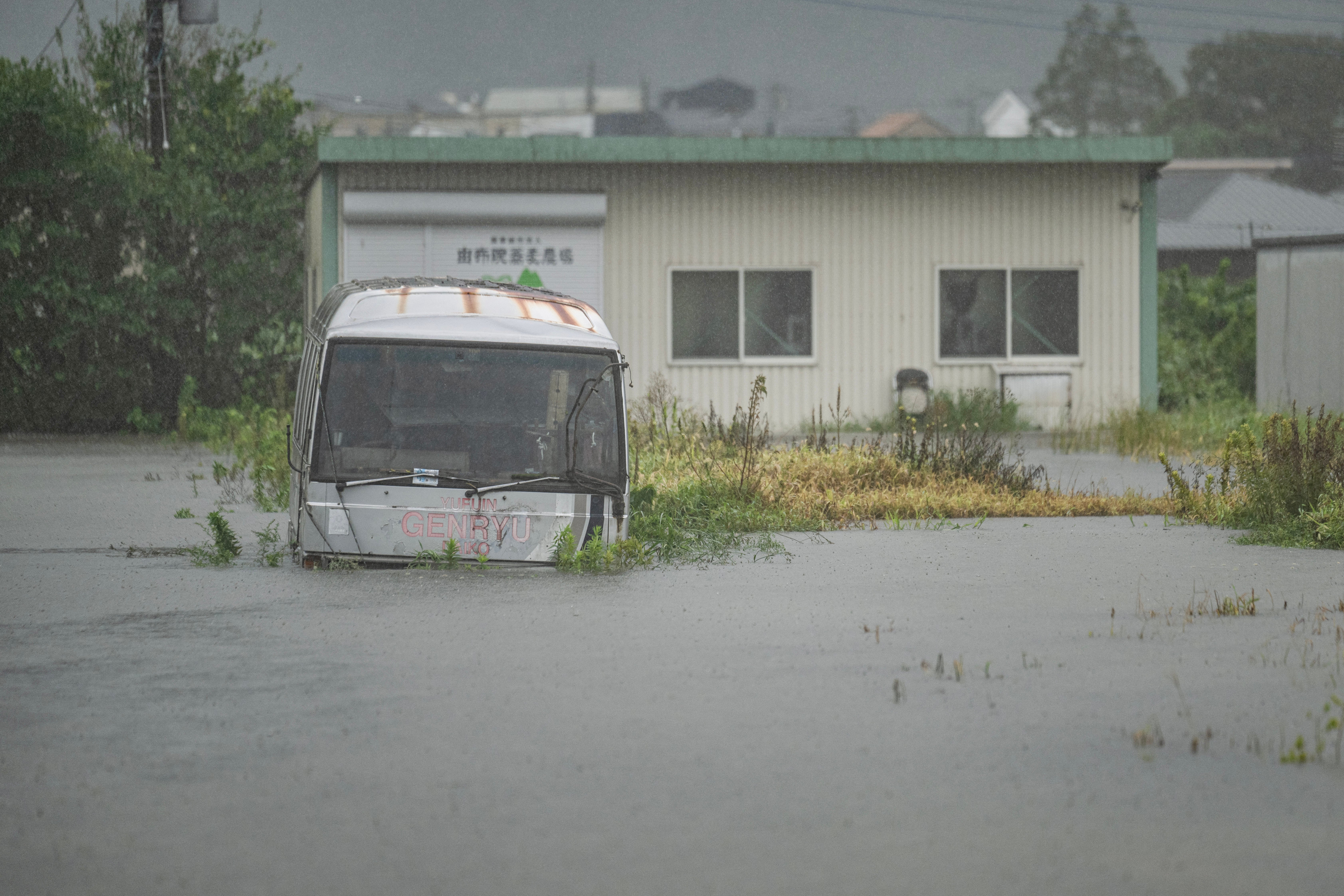 A bus is seen submerged in floodwaters in Yufu city of Oita prefecture