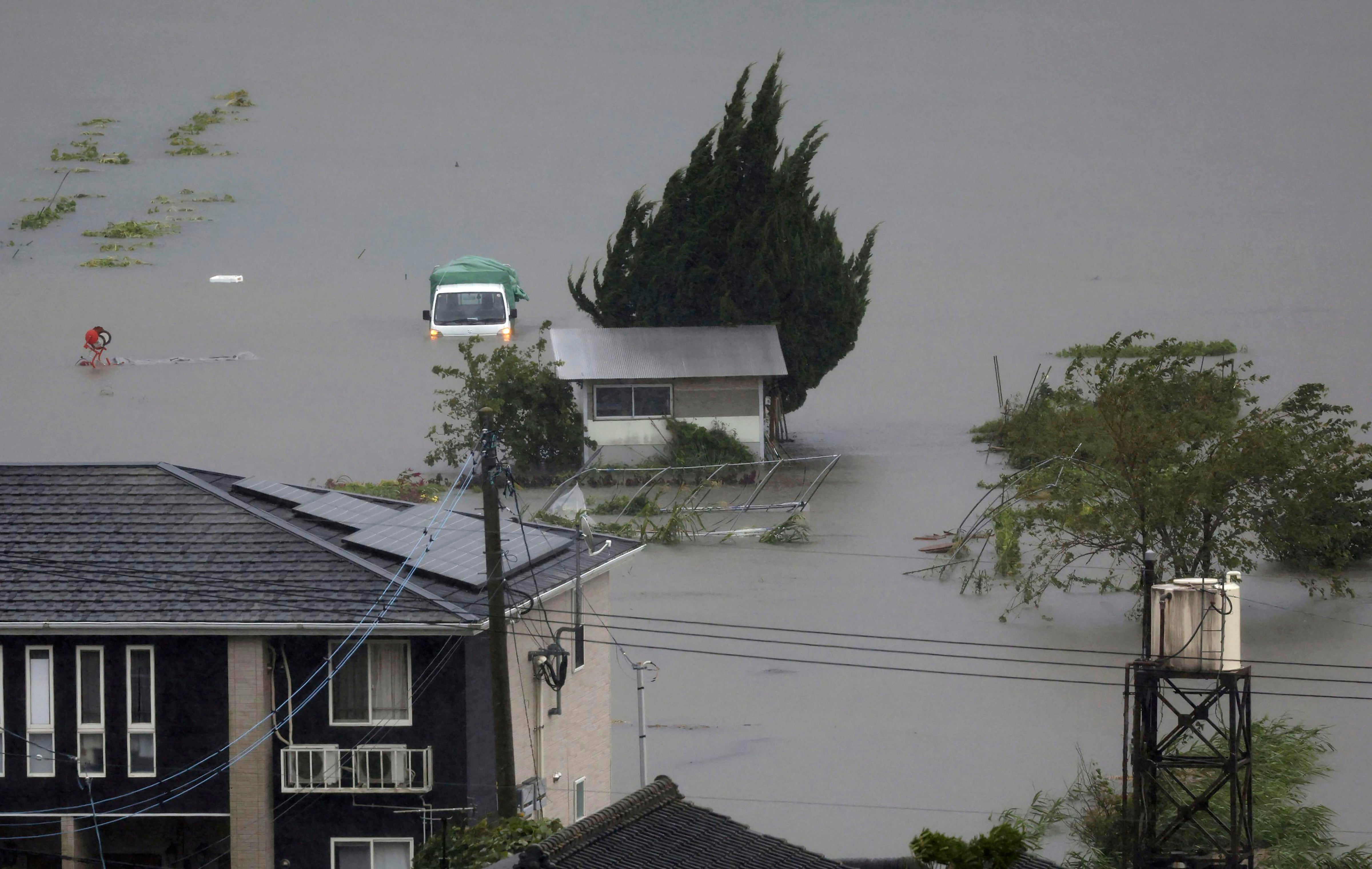 Farmland along a river is flooded by heavy rains caused by a typhoon in Yufu, Oita prefecture