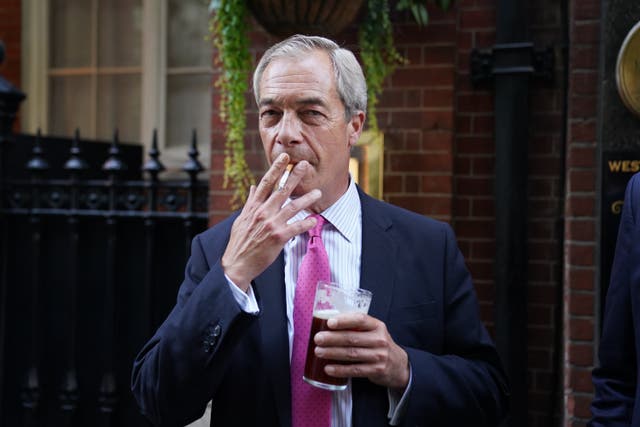 Reform UK leader Nigel Farage lights up a cigarette outside the Westminster Arms in central London (Stefan Rousseau/PA)