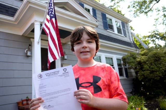 <p>Danny Doherty, 12, holds a letter from the Town of Norwood Board of Health warning his family that they may not sell homemade ice cream at an ice cream stand due to a potential state food code violation </p>