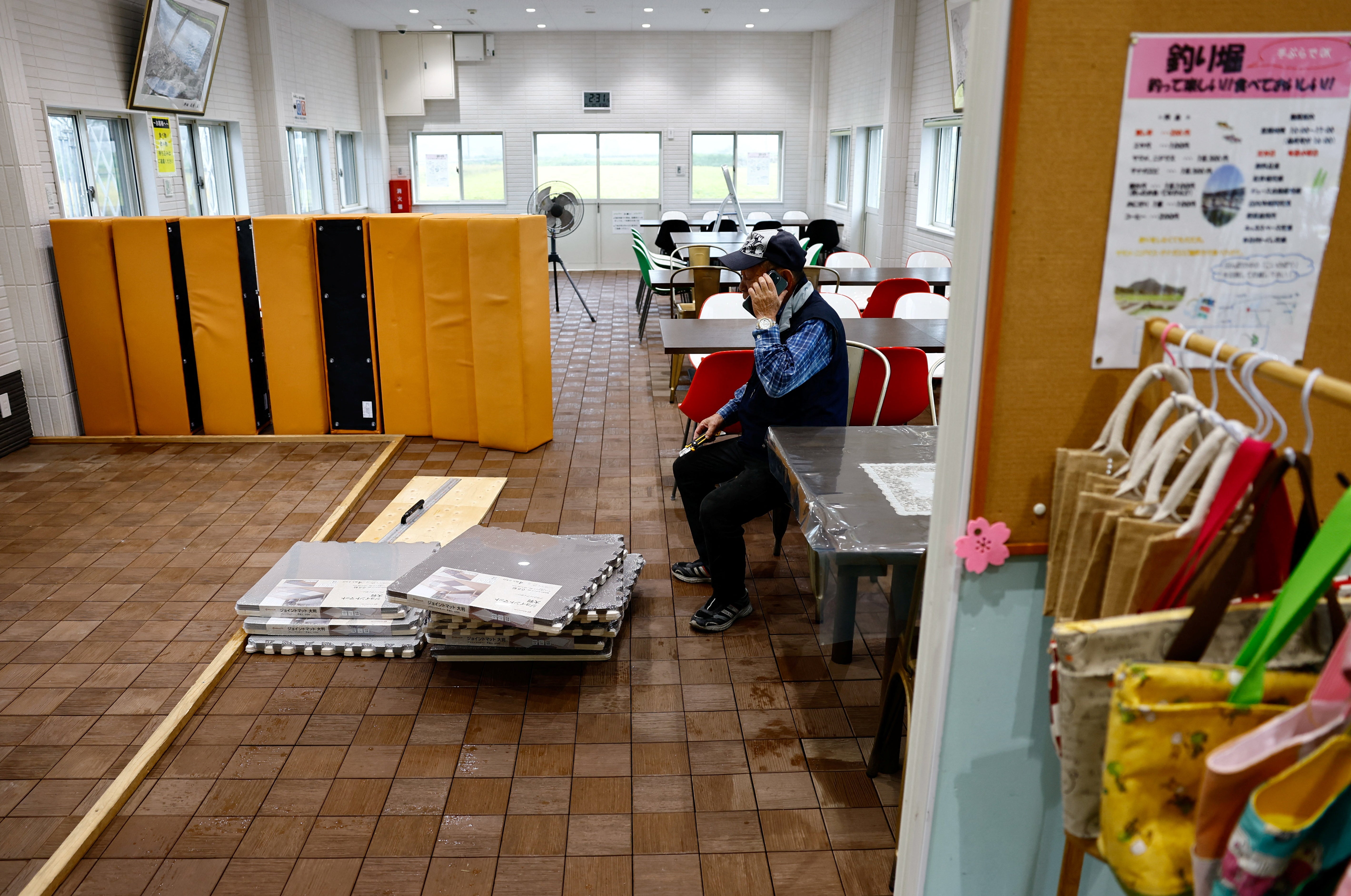 A man pauses while cleaning the floor at a fish farm, after the facility was flooded during Typhoon Shanshan in Yufu