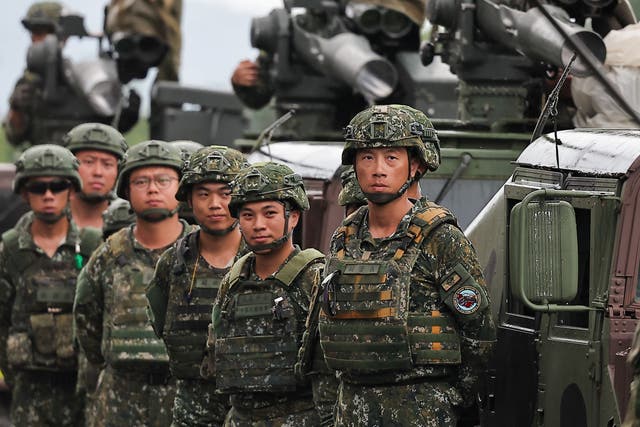 <p>Taiwanese soldiers stand next to an armoured vehicle in Pingtung County </p>