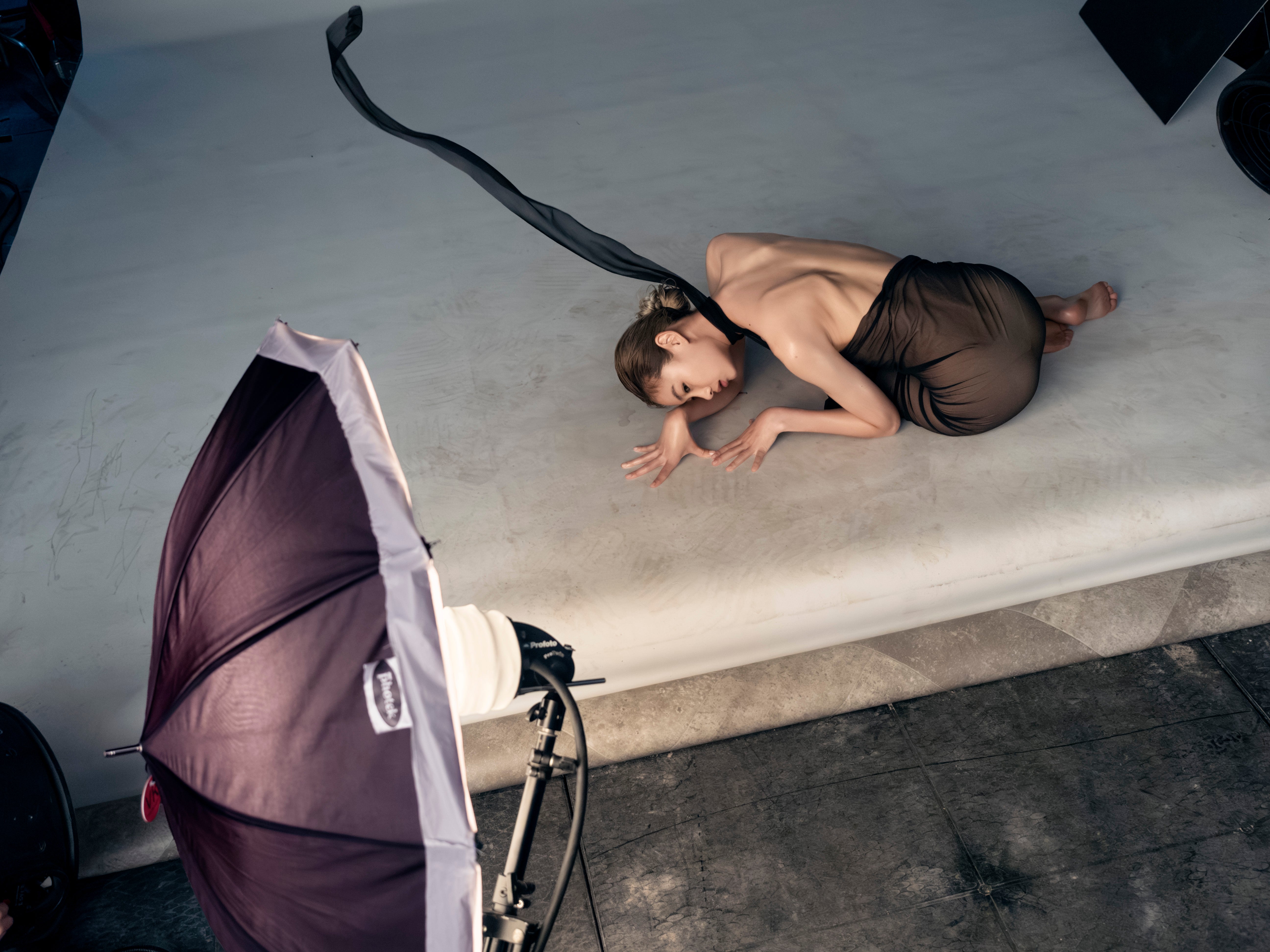 Hoyeon Jung curls on the floor inside the 2025 Pirelli Calendar studio shoot