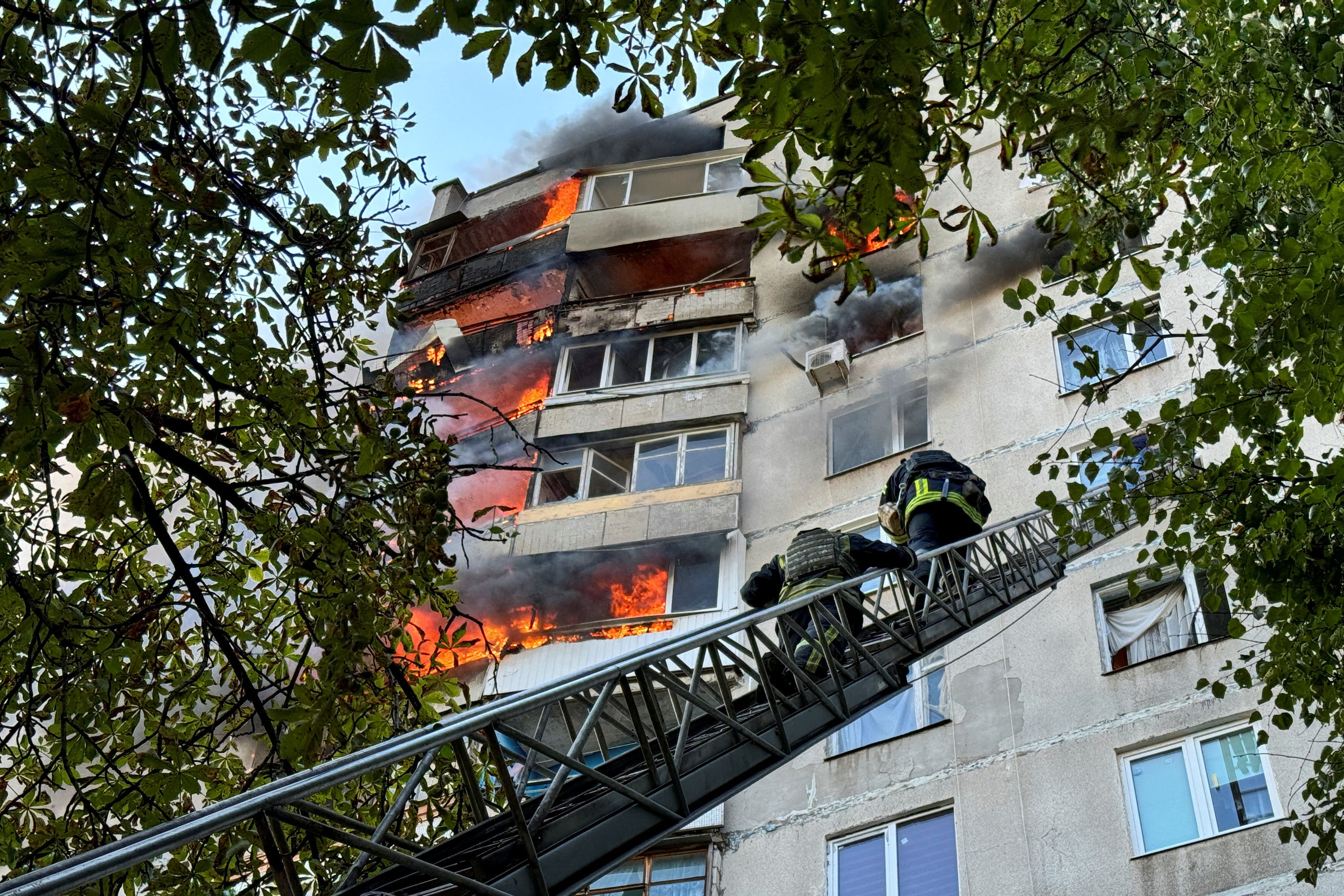 Firefighters work at a site of an apartment building hit by a Russian air strike in Kharkiv