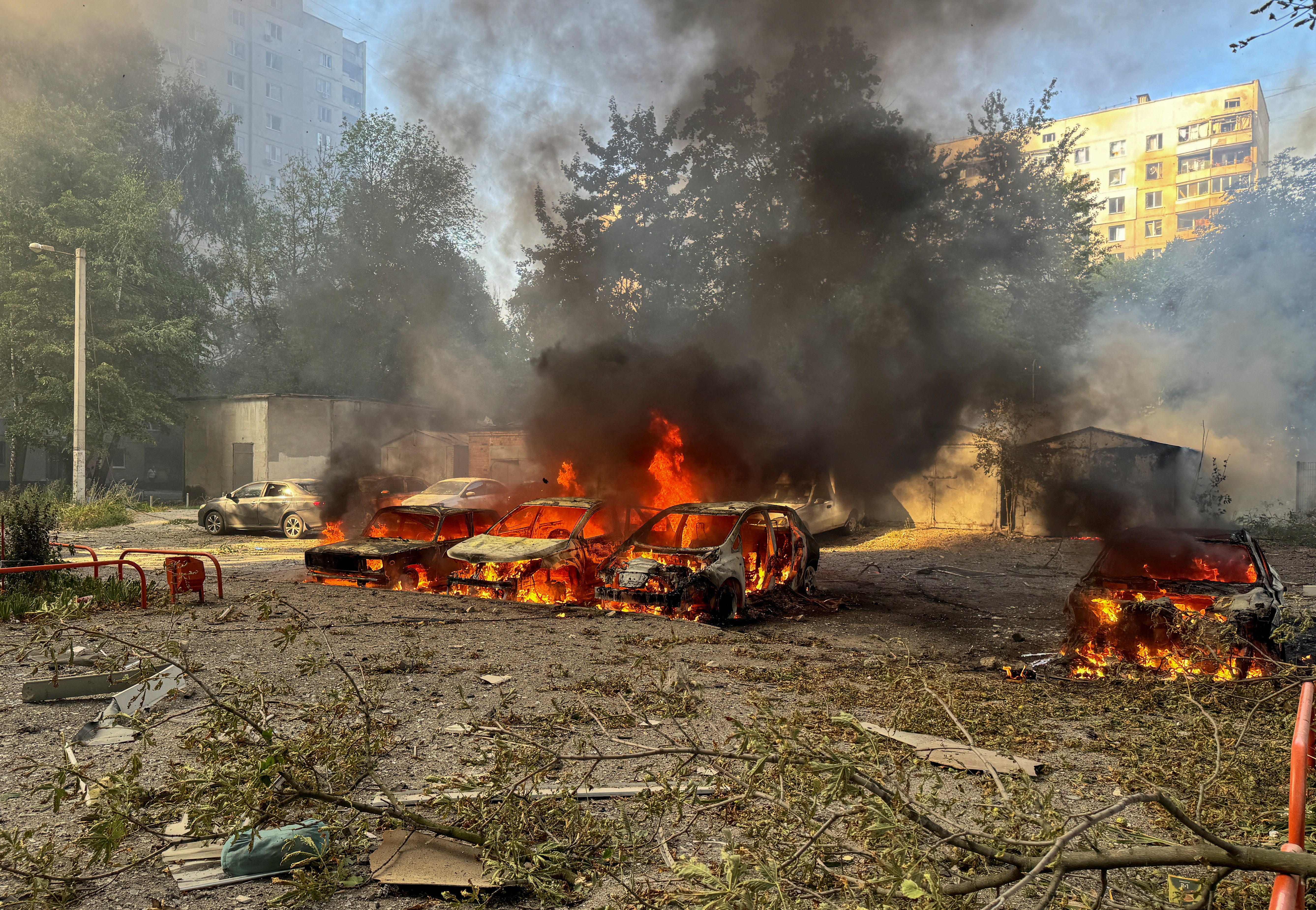 Cars burn after a Russian air strike on an apartment block in Kharkiv