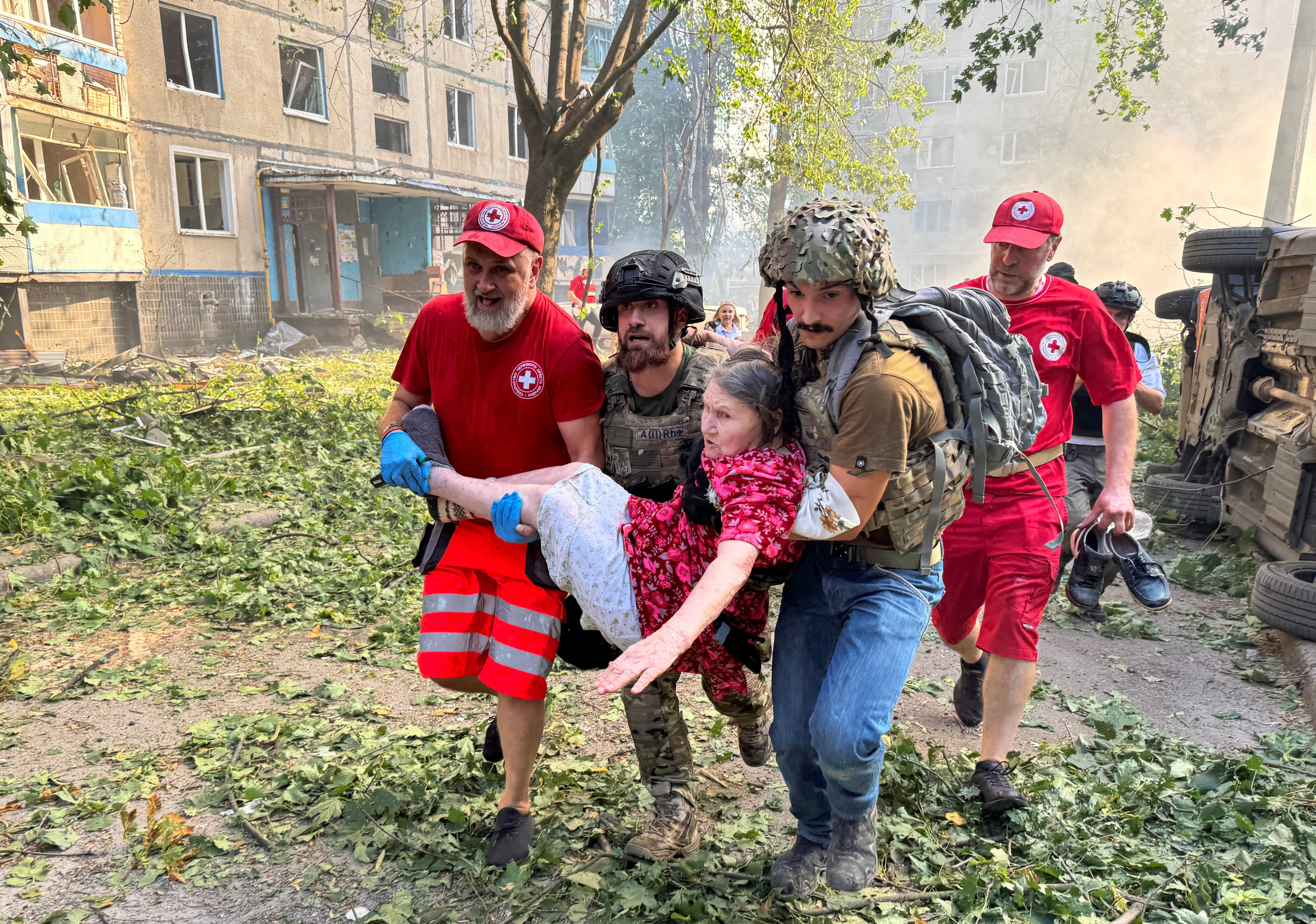 Paramedics carry a person rescued from an apartment building which burns after a Russian air strike, amid Russia's attack on Ukraine, in Kharkiv, Ukraine