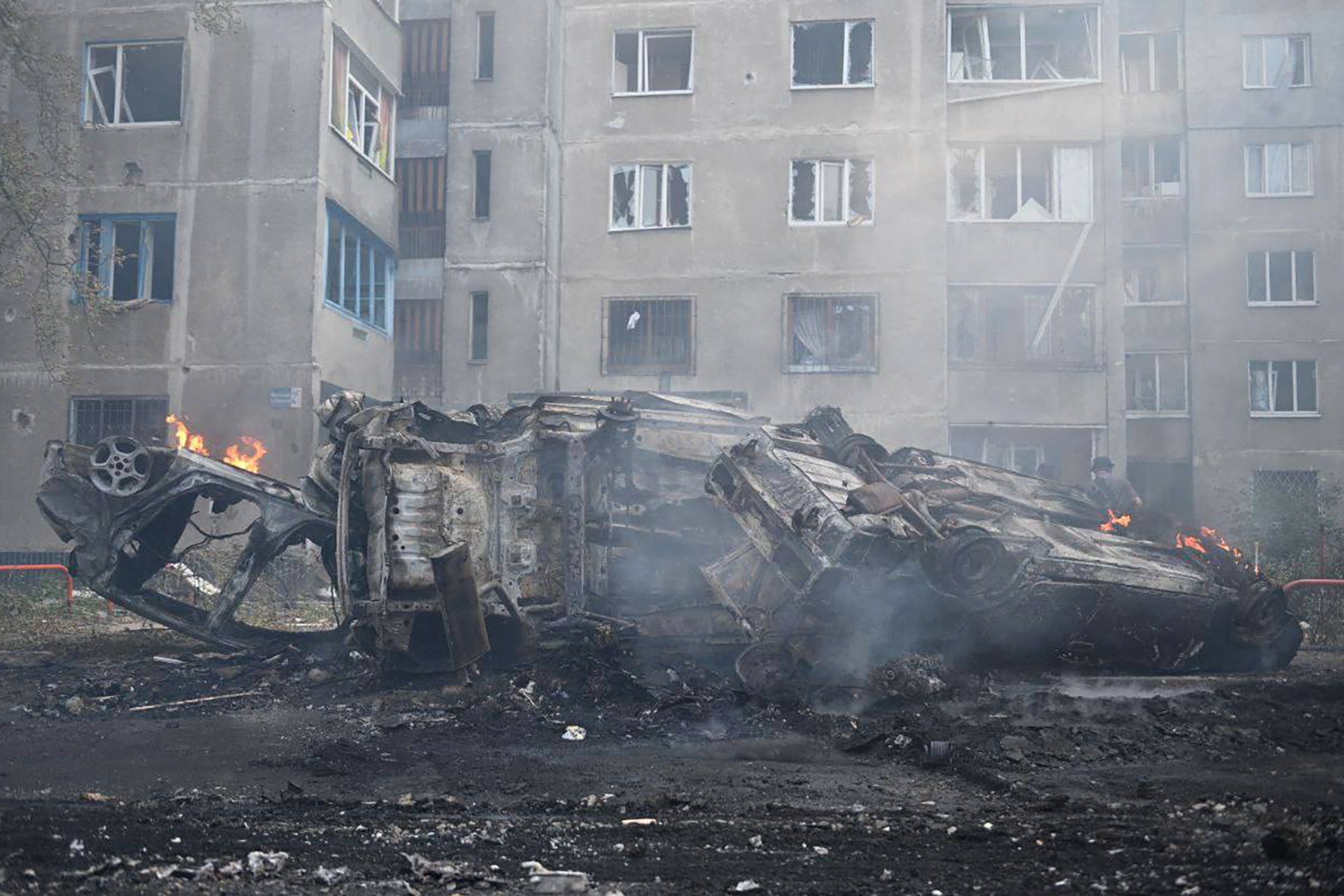 Burnt-out cars are seen in the courtyard of a damaged residential building following a missile attack in Kharkiv.