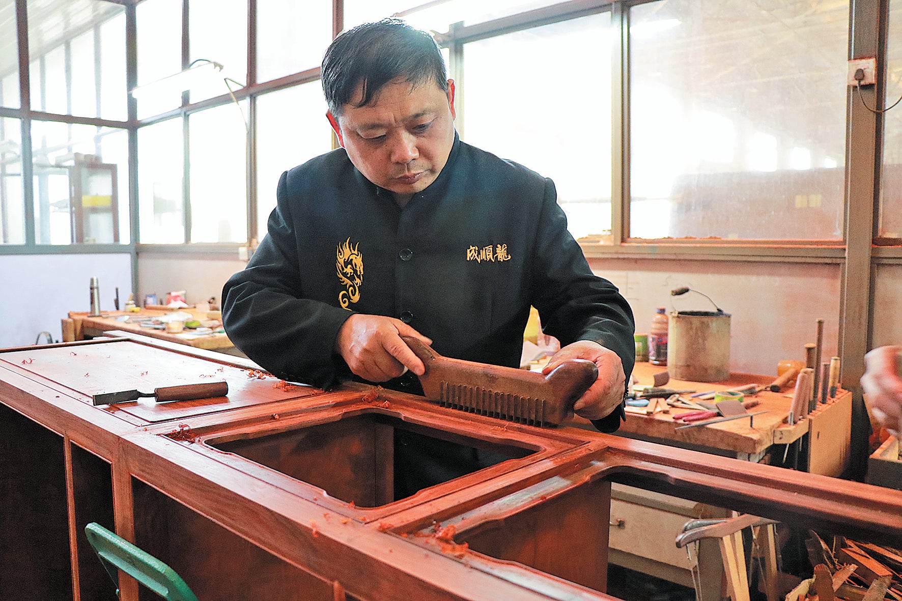 Liu Gengsheng works on a piece of wooden furniture