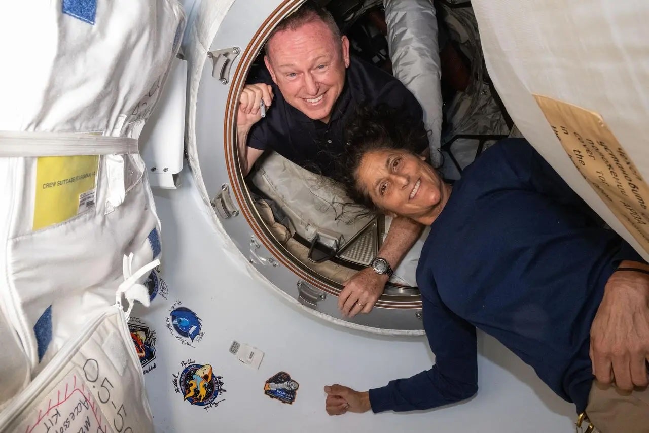 Astronauts Butch Wilmore and Suni Williams pose on June 13, 2024 inside the vestibule between the forward port on the International Space Station’s Harmony module and Boeing’s Starliner spacecraft